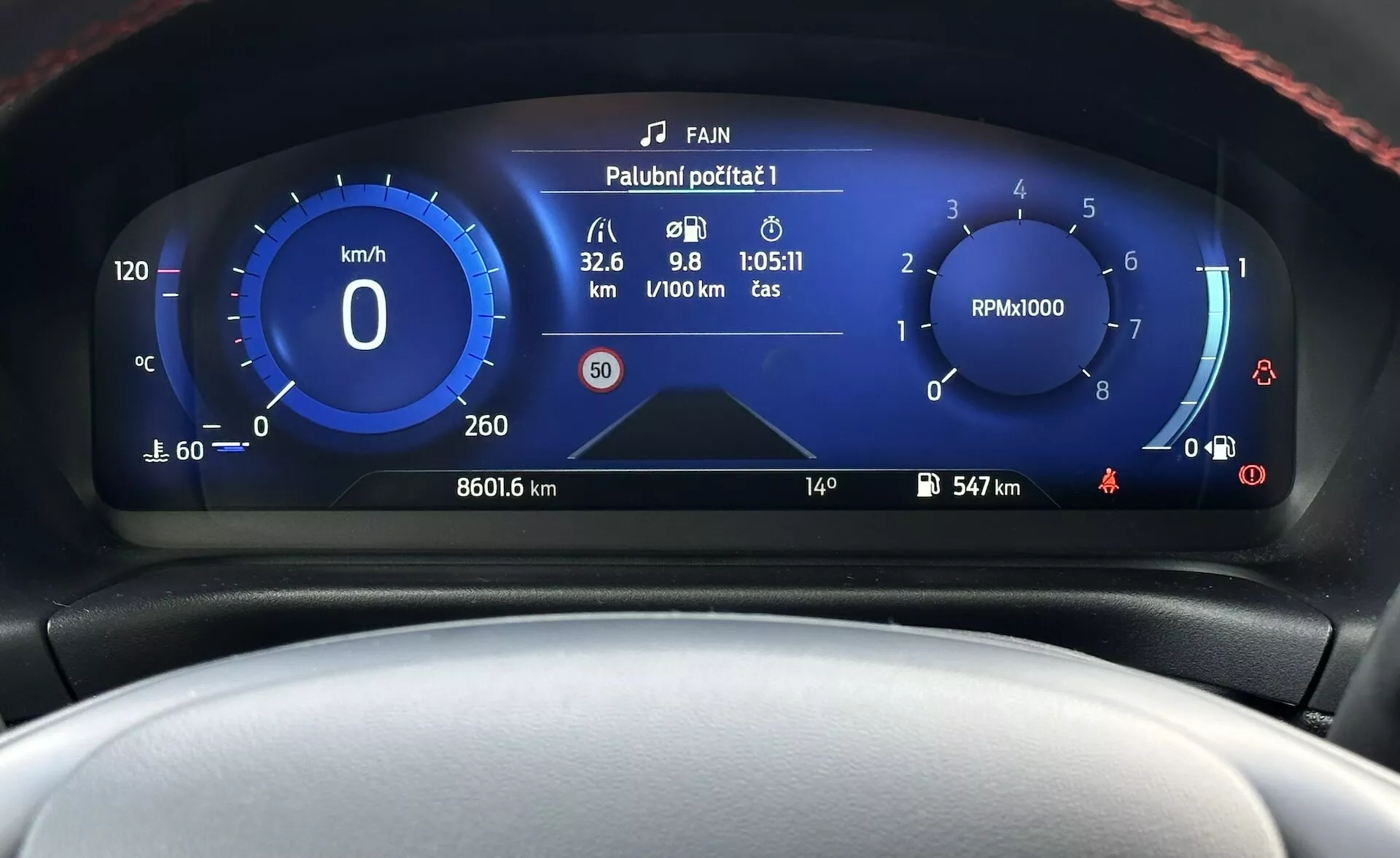 Digitálny prístrojový panel Ford Fiesta 2022 zobrazujúci detailný čelný pohľad so speedometrom, otáčkomerom, ukazovateľom spotreby paliva a rôznymi indikátormi stavu vozidla v modernom dizajne s modro-bielym farebným schémou.