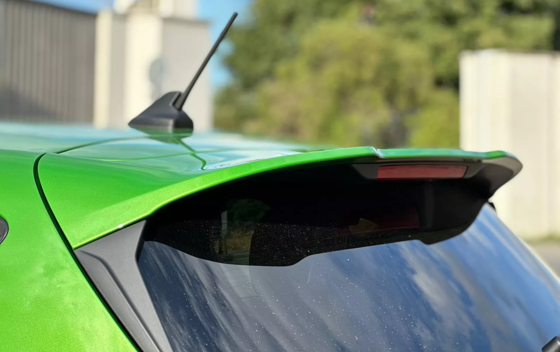 Detailný záber na zadnú časť Ford Fiesta 2022 s dôrazom na aftermarketový spoiler, výraznú zelenú farbu a integrované tretie brzdové svetlo