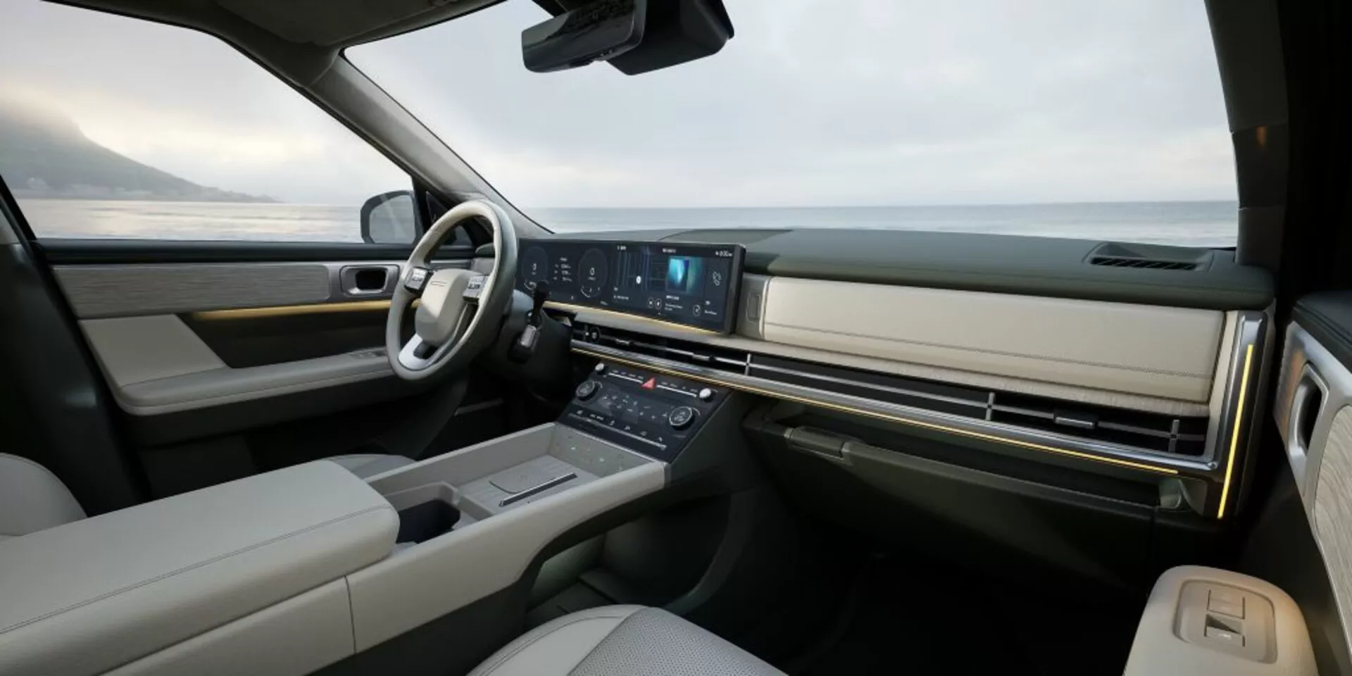 Širokouhlý pohľad na interiér Hyundai Santa-Fe 2024 (5. generácia) zo zadného sedadla smerom k palubnej doske, zdôrazňujúci luxus a pokročilú technológiu. Obsahuje multifunkčný infotainment systém s veľkým, kontinuálnym displejom, minimalistickými klimatizačnými tlačidlami, volant s viacerými ovládacími prvkami, digitálny prístrojový panel (nie je viditeľný) a možný panoramatický čelné sklo naznačujúce vysoko kvalitný dizajn s koženým a dreveným alebo kovovým čalúnením.