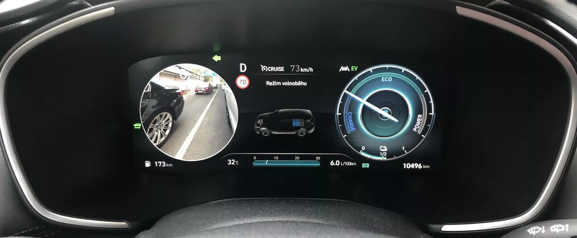 Pohľad vodiča na moderný digitálny prístrojový panel Hyundai Santa Fe 2020, ktorý zobrazuje rôzne informácie, vrátane digitálneho rýchlomera na 0 km/h, ukazovateľa spotreby energie, centrálneho obrazu auta s bezpečnostnými indikátormi, vonkajšej teploty 3 °C, plného stavu paliva, obrazu z bočnej kamery zrkadla, ukazovateľa prevodového režimu 'D', ikon stavu vozidla a počítadla kilometrov, ktoré ukazuje odhadovaný dojazd 1069 km, to všetko na širokouhlom displeji spájajúcom monitorovanie stavu vozidla, bezpečnostné funkcie a infotainmentové systémy.