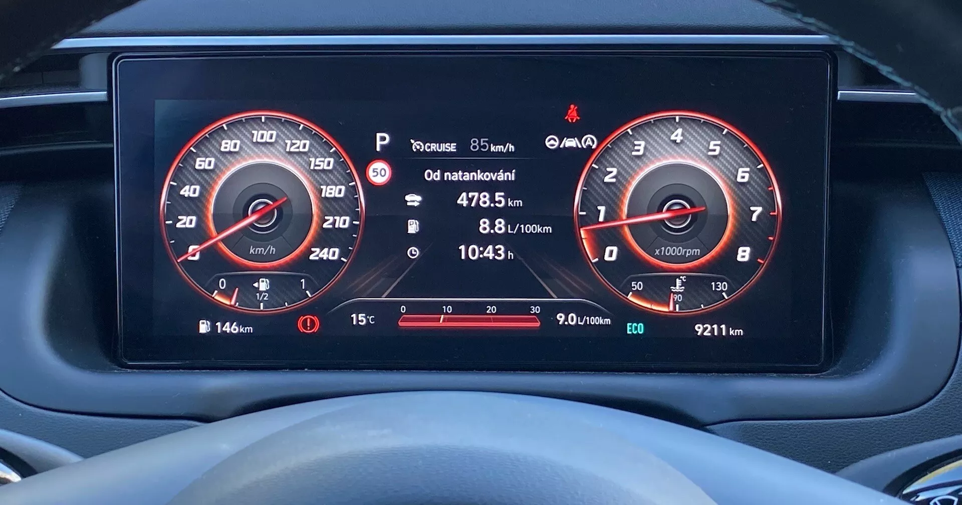 Zblízka digitálneho prístrojového panela v Hyundai Tucson 2020 z pohľadu vodiča, zobrazujúce vysoko rozlíšené displeje rýchlomera (do 260 km/h) a otáčkomera (do 7000 ot./min.), ukazovateľa paliva, informácie o ceste, upozornenie na tlak v pneumatikách, vonkajšiu teplotu a rôzne výstražné ikony.
