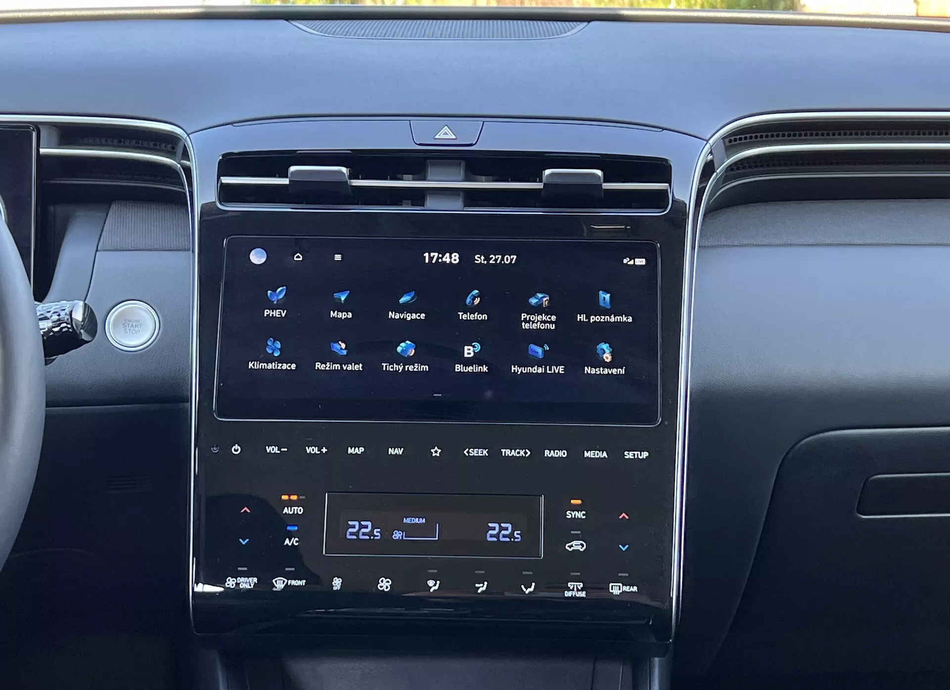 Interiér Hyundai Tucson 2020 ukazuje stredovú konzolu s veľkým, vertikálnym dotykovým displejom informačného systému, dvojzónovou klimatizáciu a okolité vetracie otvory, odrážajúc modernú technológiu vozidla a luxus