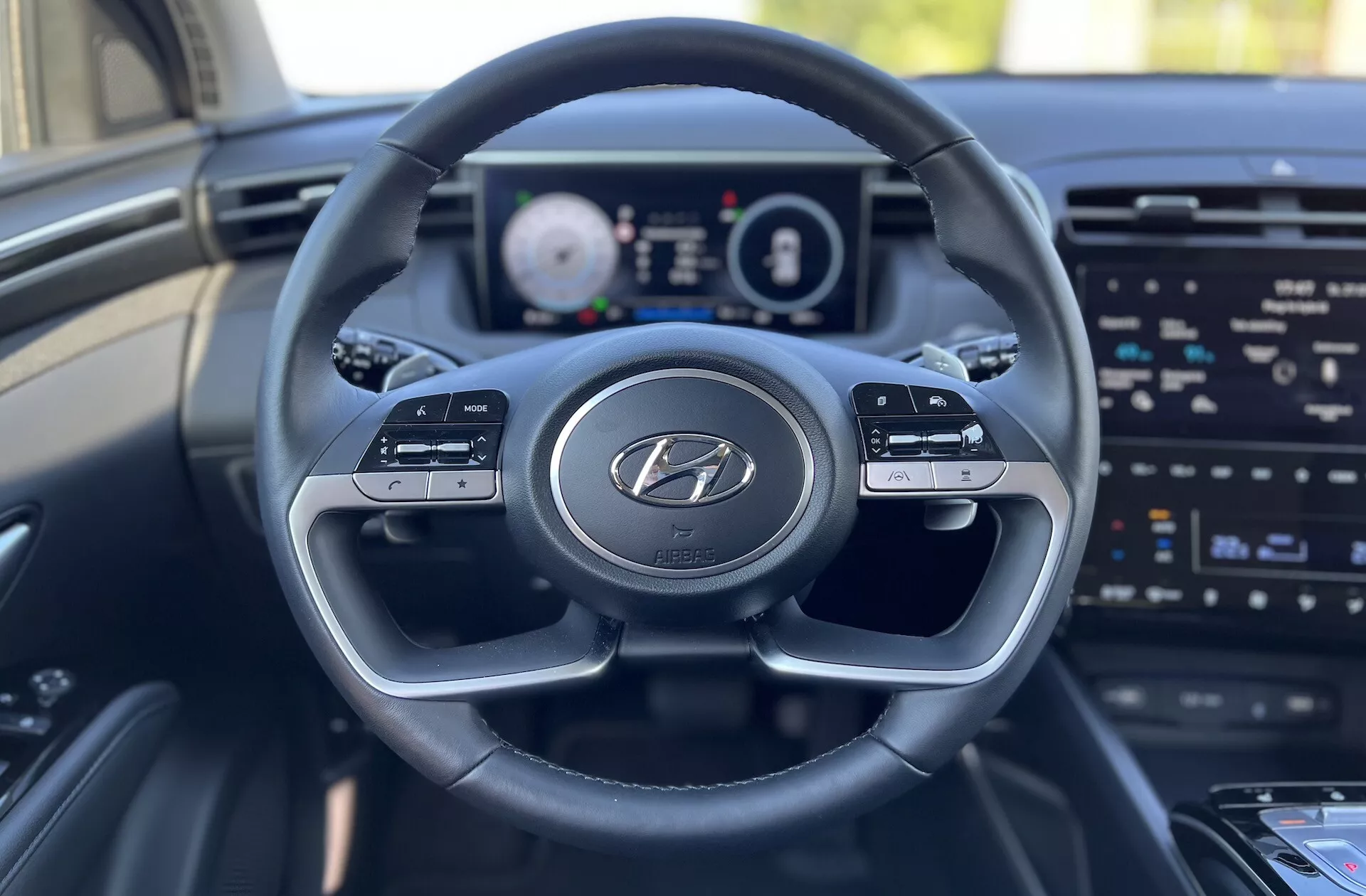 Interiér Hyundai Tucson 2020 z pohľadu vodiča ukazujúci volant s logom Hyundai, digitálny prístrojový panel a obrazovku infotainmentu