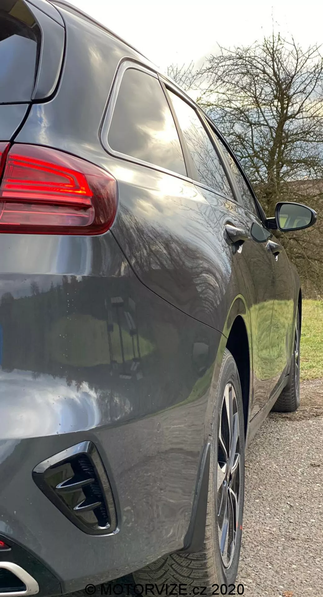 Detailný pohľad na pravú bočnú stranu moderného SUV z mierne zadného uhla, ukazujúci zadnú časť a bočný profil od kľučky zadných dverí po zadné svetlá, s hladkými aerodynamickými líniami, tmavým kovovým lakom, veľkými zliatinovými kolesami, dvojitými koncovkami výfuku, tónovanými oknami a zadným svetlom s moderným dizajnom.