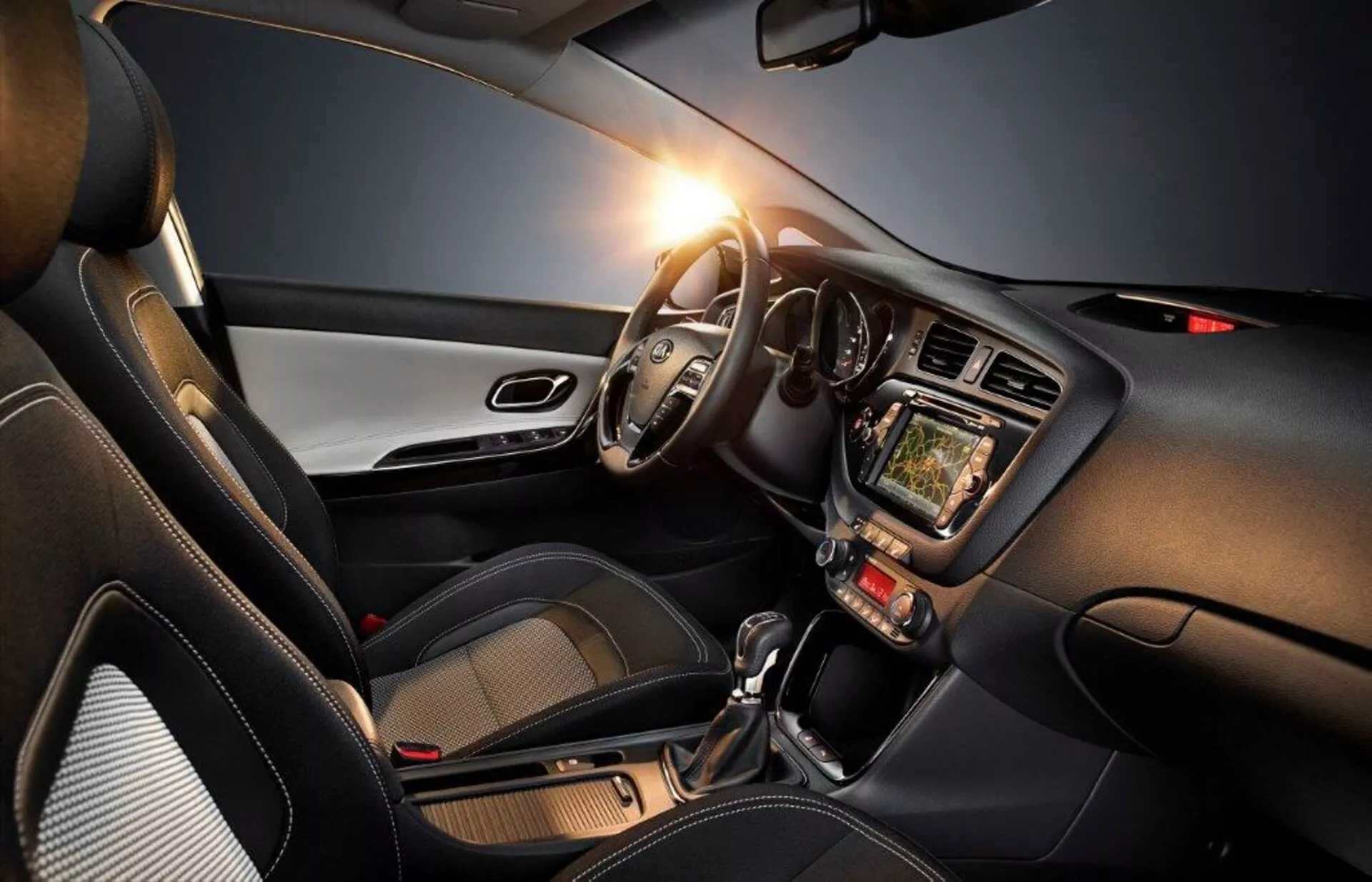 Interiér Kia Cee'd z roku 2009 zdôrazňujúci stranu vodiča s volantom vľavo, prístrojovou doskou, dotykovým infotainment systémom, ovládacími prvkami klímy, automatickou prevodovkou a modernými designovými akcentmi, zdôrazňujúc technológiu, pohodlie a športový aspekt