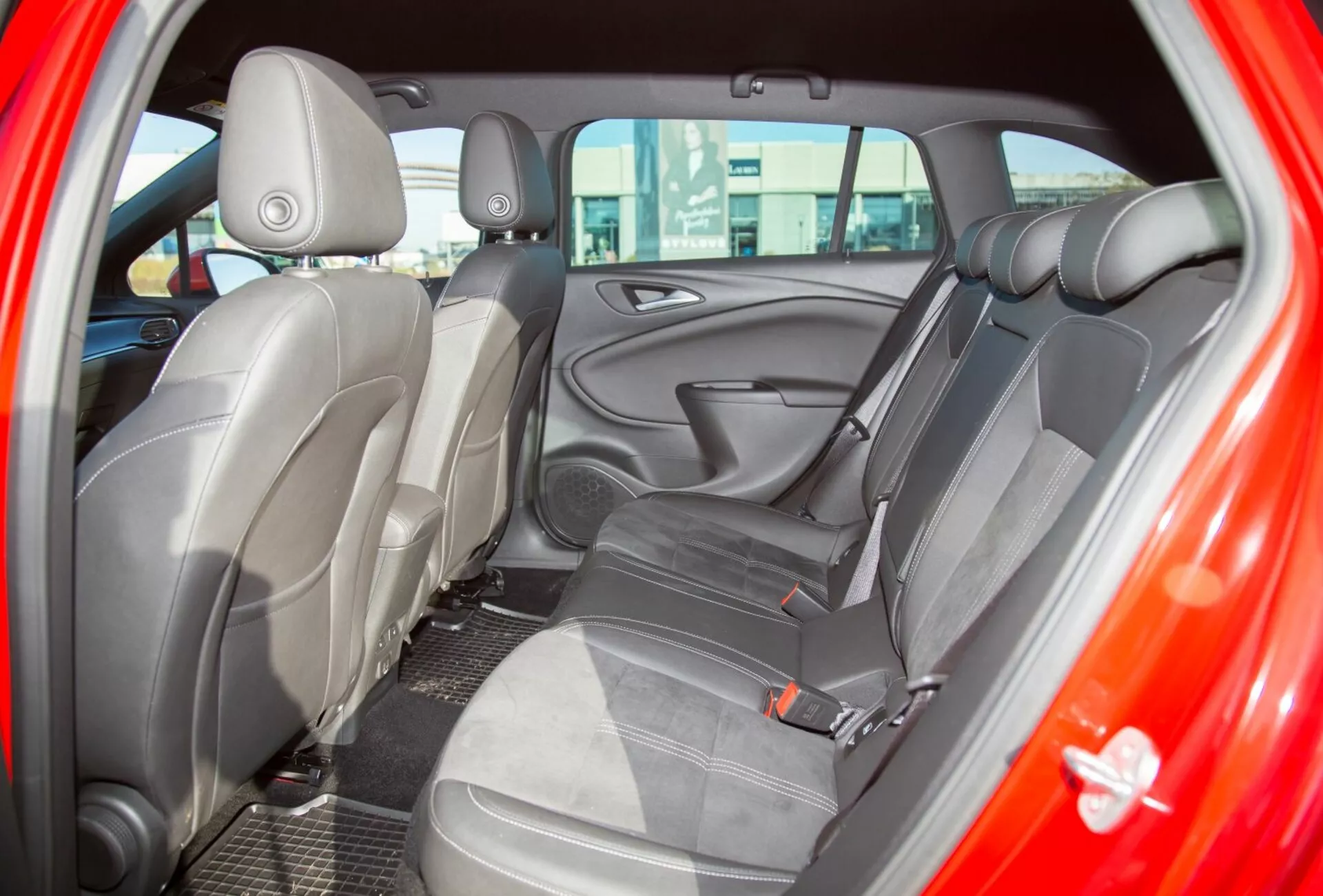 Detailný pohľad na interiér Kia Ceed z roku 2009, zobrazenie zadného sedadla z pohľadu zadných dverí vodiča, s dôrazom na čalúnenie z dvojfarebnej látky a ergonomický dizajn sedadiel pre zlepšené pohodlie