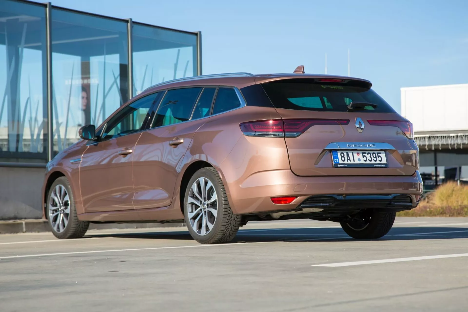 Kombi Kia Ceed 2009 zachytené zo zadného trojštvrtečného uhla zdôrazňujúce zadné svetlá, dizajn zadného nárazníka, výfukovú rúru a kontúry bočnej karosérie na slnečný deň
