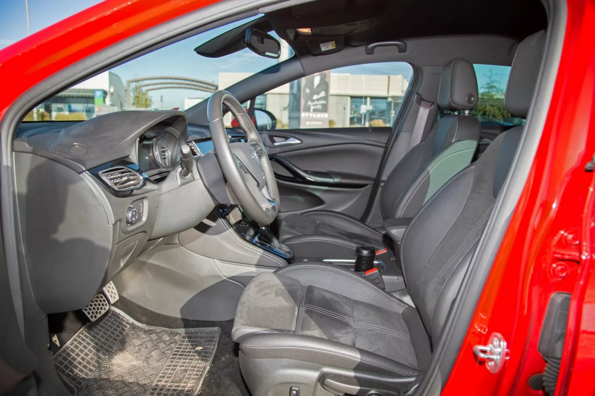 Interiér Kia cee'd z roku 2009 so zobrazeným volantom s ovládacími prvkami, centrálnou obrazovkou infotainmentu, viditeľným prístrojovým panelom, stredovou konzolou s ďalšími ovládacími prvkami, čalúnenými sedadlami s opierkami hlavy, detailným vnútrom dverí s ovládacími prvkami, dvojfarebnou farebnou schémou, pohľadom na spätné a vodičské bočné zrkadlo, odolnými podlahovými rohožami a signálmi indikátorov airbagov, zachytávajúcom komplexný dizajn a technologicky zamerané funkcie z externého bočného pohľadu