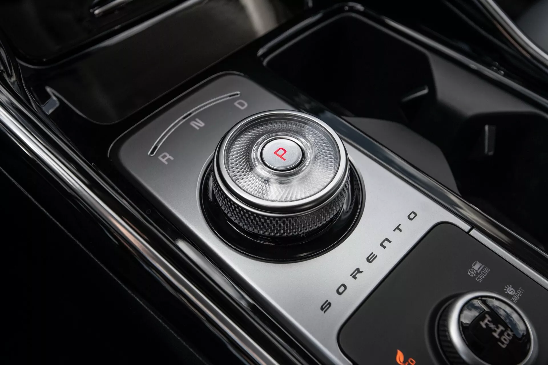 Detailný pohľad na rotačný volič prevodovky Kia Sorento MQ4 facelift 2024 v polohe 'P', ktorý zdôrazňuje moderný a luxusný interiérový dizajn s lesklými čiernymi povrchmi a kovovými akcentmi