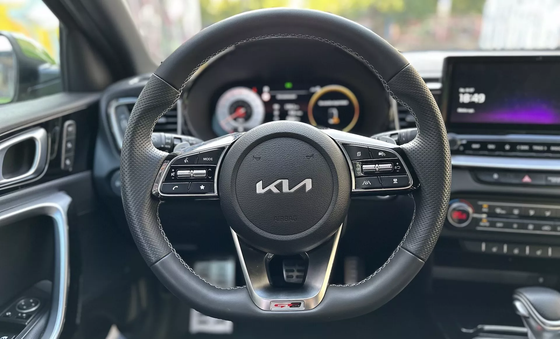 Pohľad z perspektívy vodiča vo vnútri Kia Xceed 2022 ukazujúci palubnú dosku, volant s ovládacími tlačidlami, digitálno-analógový prístrojový panel a multimediálne stredovú konzolu
