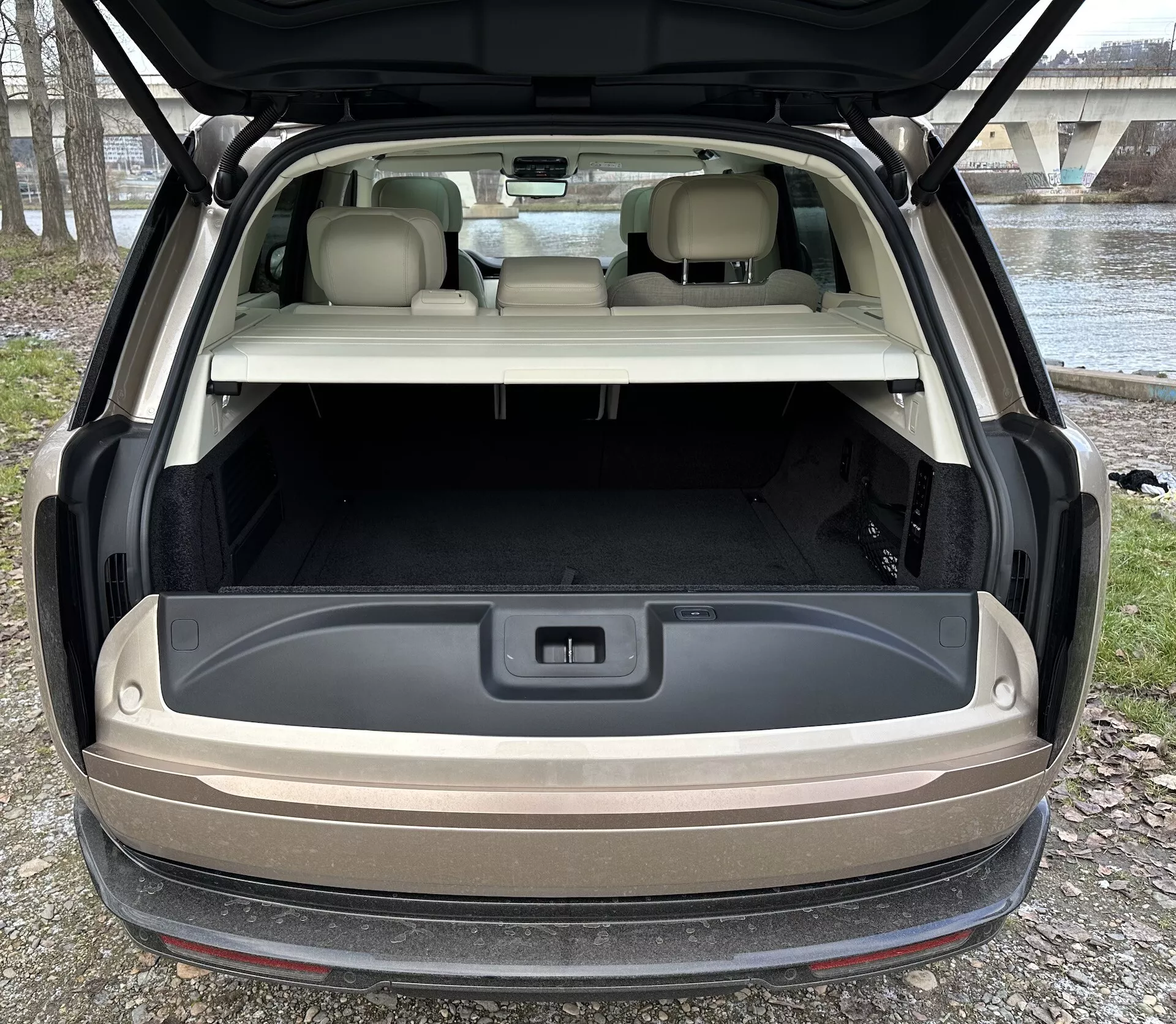 Zadný pohľad na Land Rover Range Rover 2021 s otvoreným hatchbackom ukazujúcim priestranný nákladný priestor, pokročilé osvetlenie a 12-voltovú zásuvku v prirodzenom vonkajšom svetle