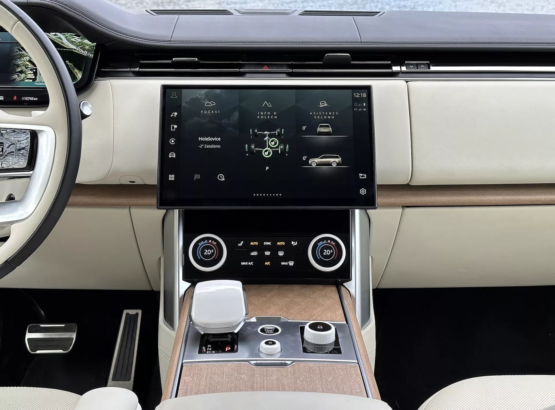 Land Rover Range Rover 2021 s moderným interiérom, zameraným na stredovú konzolu a systém infotainment s vysokým rozlíšením dotyková obrazovka, vzduchové mriežky s chrómovými akcentmi, dvojzónovú klimatizáciu, otočný ovládací gombík pre navigáciu systému a luxusné dvojfarebné kožené sedadlá s detailmi z dreveného obloženia.