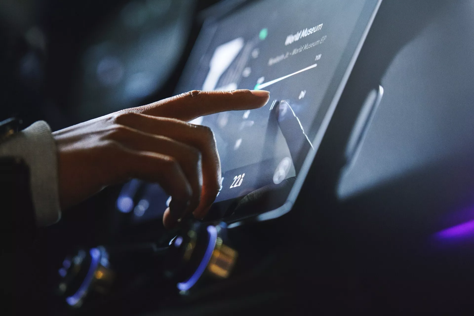 Detailný pohľad na ruku osoby interagujúcej s dotykovou obrazovkou infotainment systému Lynk & Co 01 (2021 - 1. generácia), zdôrazňujúci modernú automobilovú technológiu a ergonomický dizajn