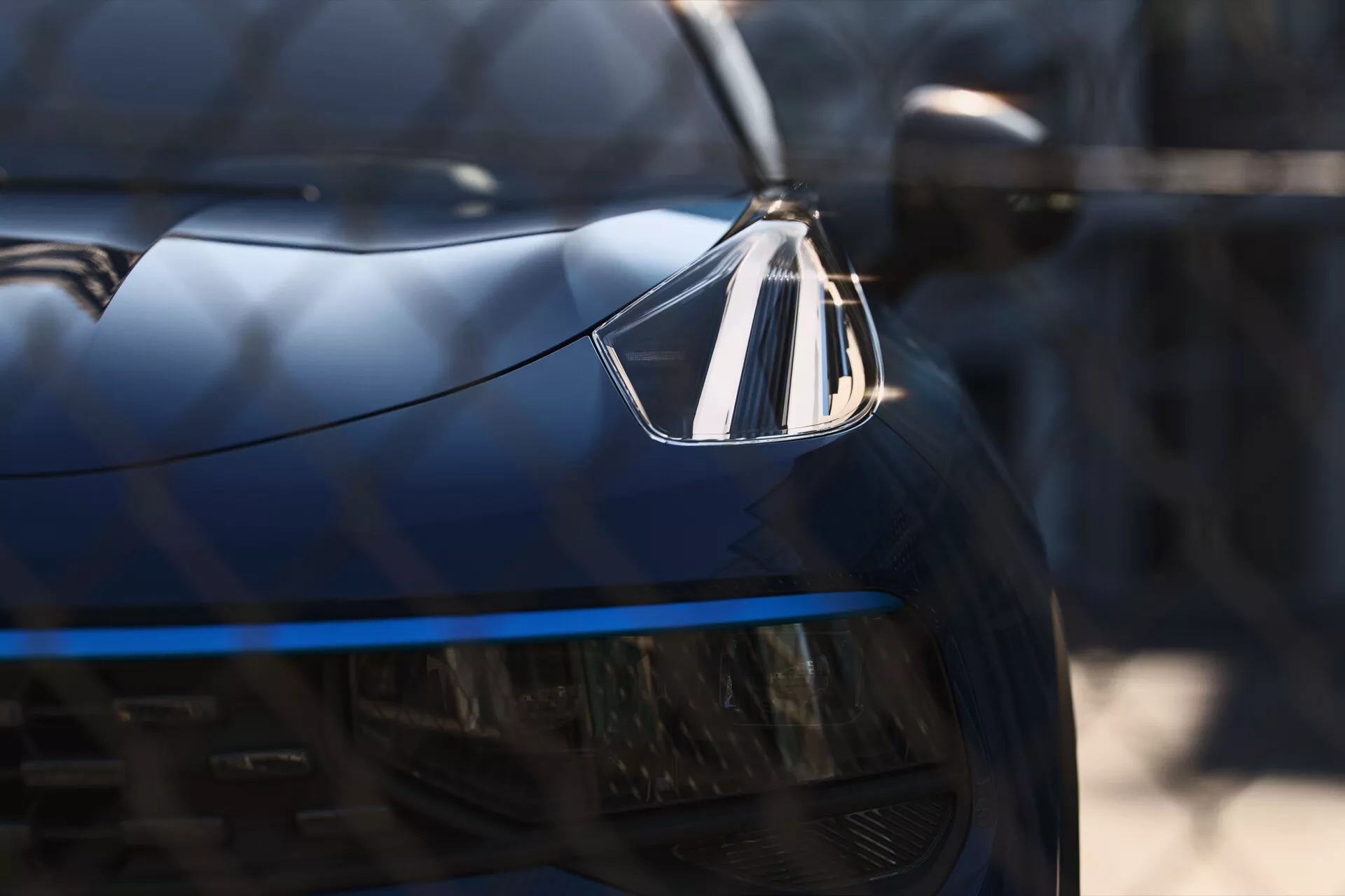 Detailný pohľad na svetlomet a mriežku Lynk & Co 01 z roku 2021, zdôraznenie LED osvetlenia a luxusného emblému, pohľad zľava spredu