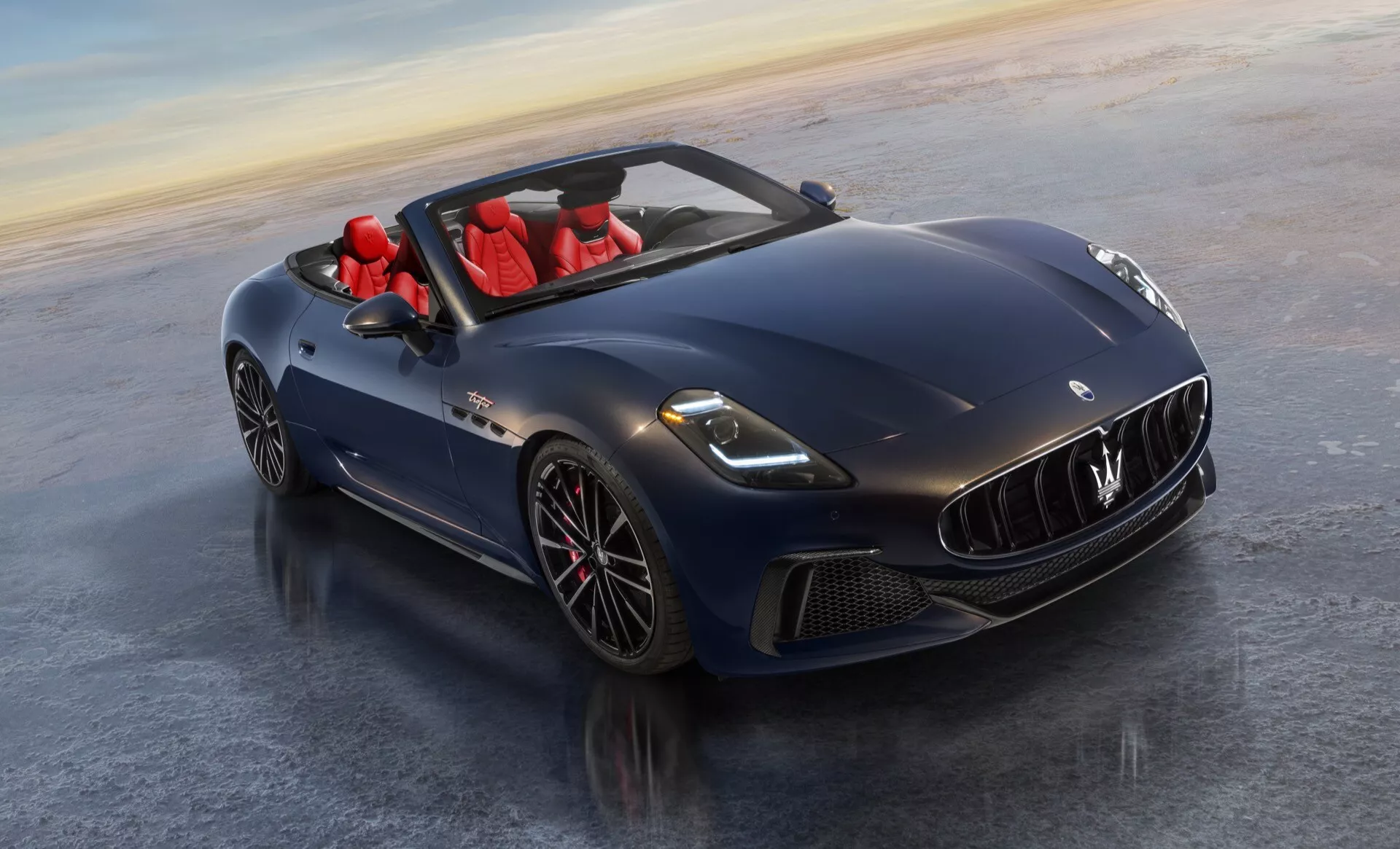 Maserati GranCabrio 2. generácie z roku 2024 v hlbokomodrej s červeným interiérom, predvádzajúci LED svetlomety, aerodynamický dizajn, sklopnú strechu, prednú mriežku a zliatinové disky z vysokého uhla prednej časti.