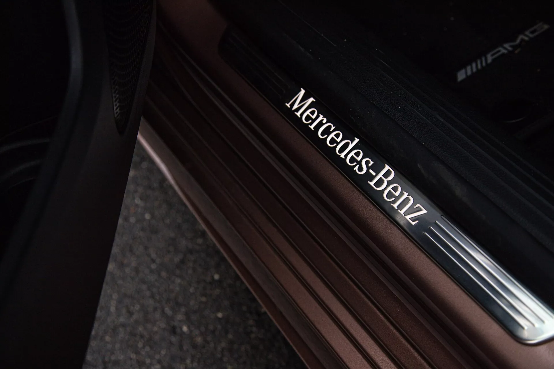 Detailný záber na prah dverí Mercedes-Benz triedy A 2022 s kovovým písmom Mercedes-Benz a AMG na prémiovom povrchu