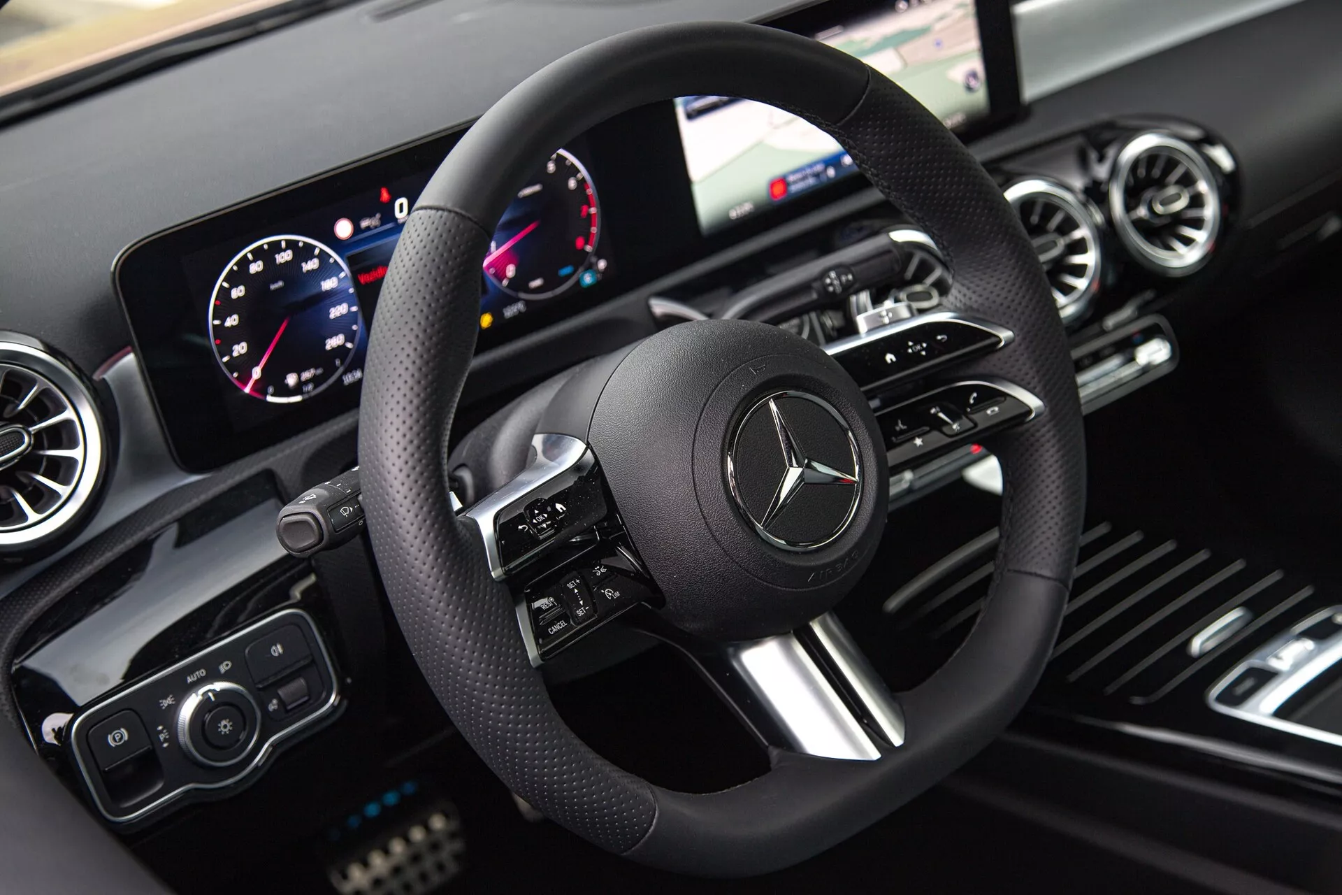 Interiér Mercedes-Benz triedy A z roku 2022 zobrazujúci pohľad vodiča na volant, digitálnu palubnú dosku a informačno-zábavný systém s dôrazom na moderné technológie a luxusný dizajn