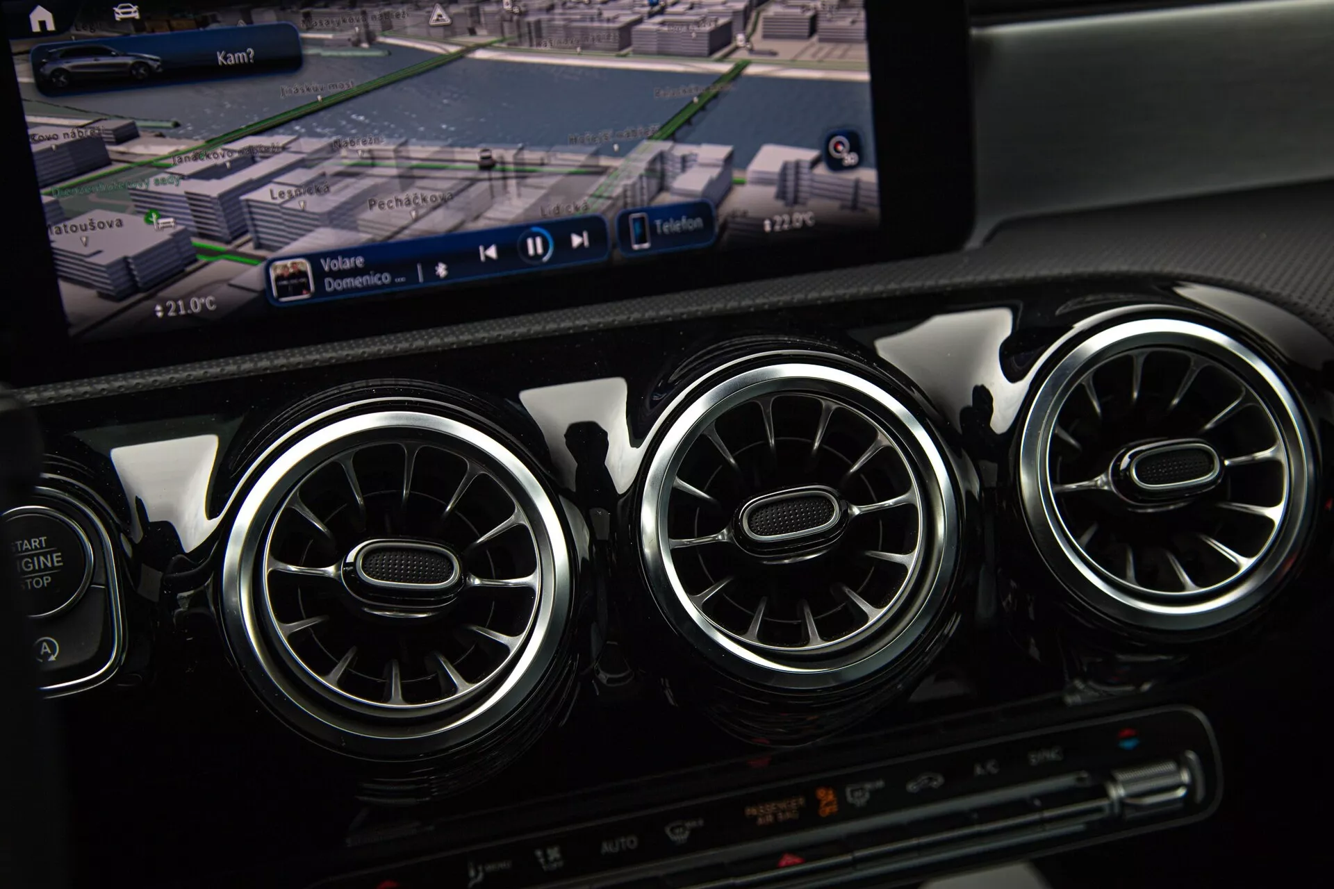 Stredová konzola Mercedes-Benz triedy A 2022 s klimatizačnými otvormi, GPS navigáciou na obrazovke multimediálneho systému a nastaveniami klimatizácie
