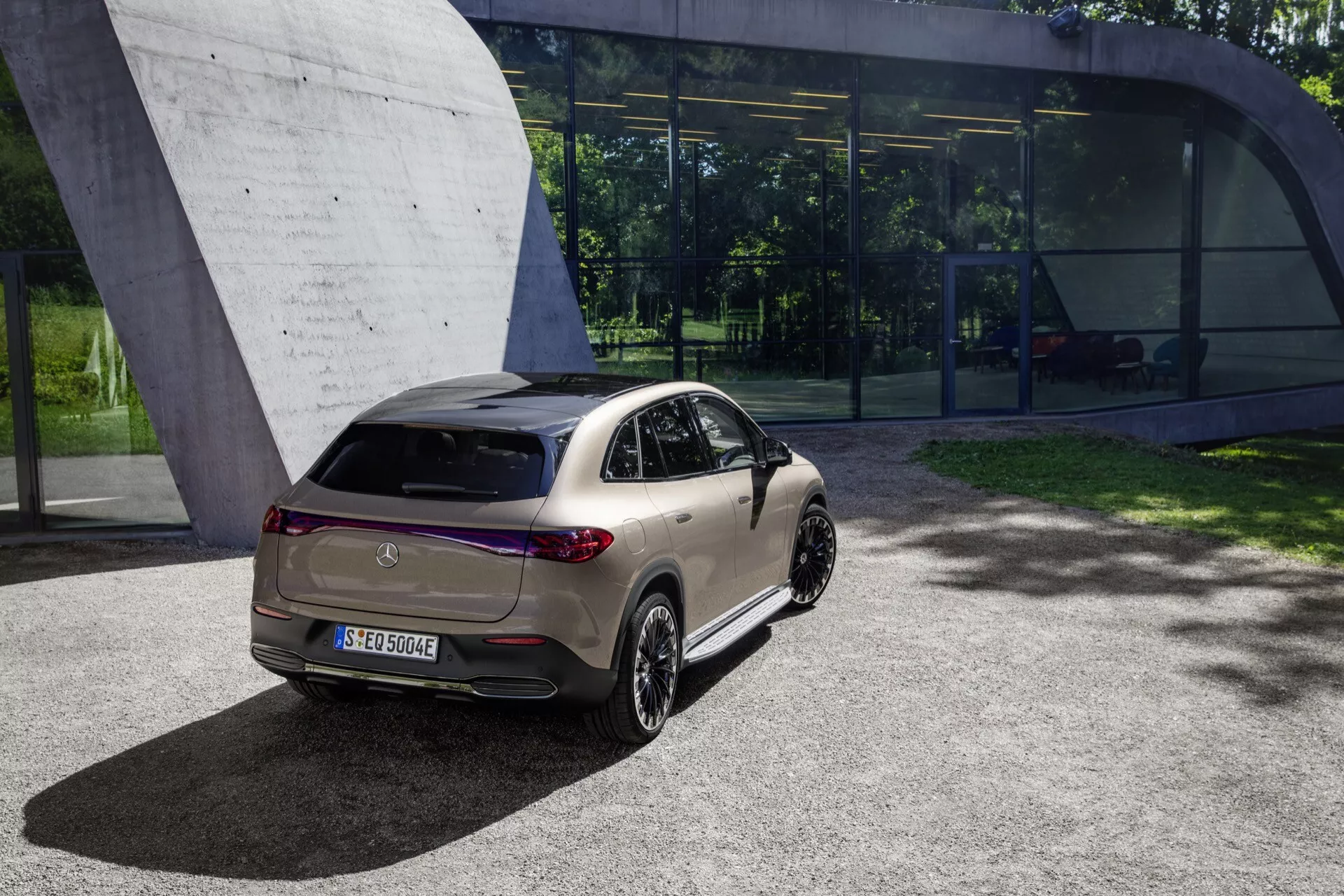 Moderný kompaktný hatchback 2023 na slnku, ukazujúci LED zadné svetlá, parkovacie senzory, športový spoiler na streche a dvojfarebnú schému lakovania na hrubom, škvrnitom povrchu