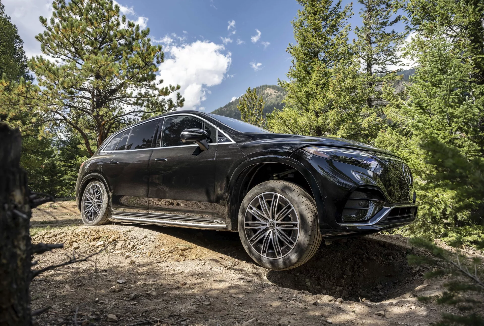 Predný trojštvrtinový pohľad na Mercedes EQS SUV 2022, zobrazujúci jeho elegantný dizajn, pokročilé LED svetlomety, panoramatickú strechu a prémiové zliatinové kolesá v sofistikovanom mestskom prostredí.