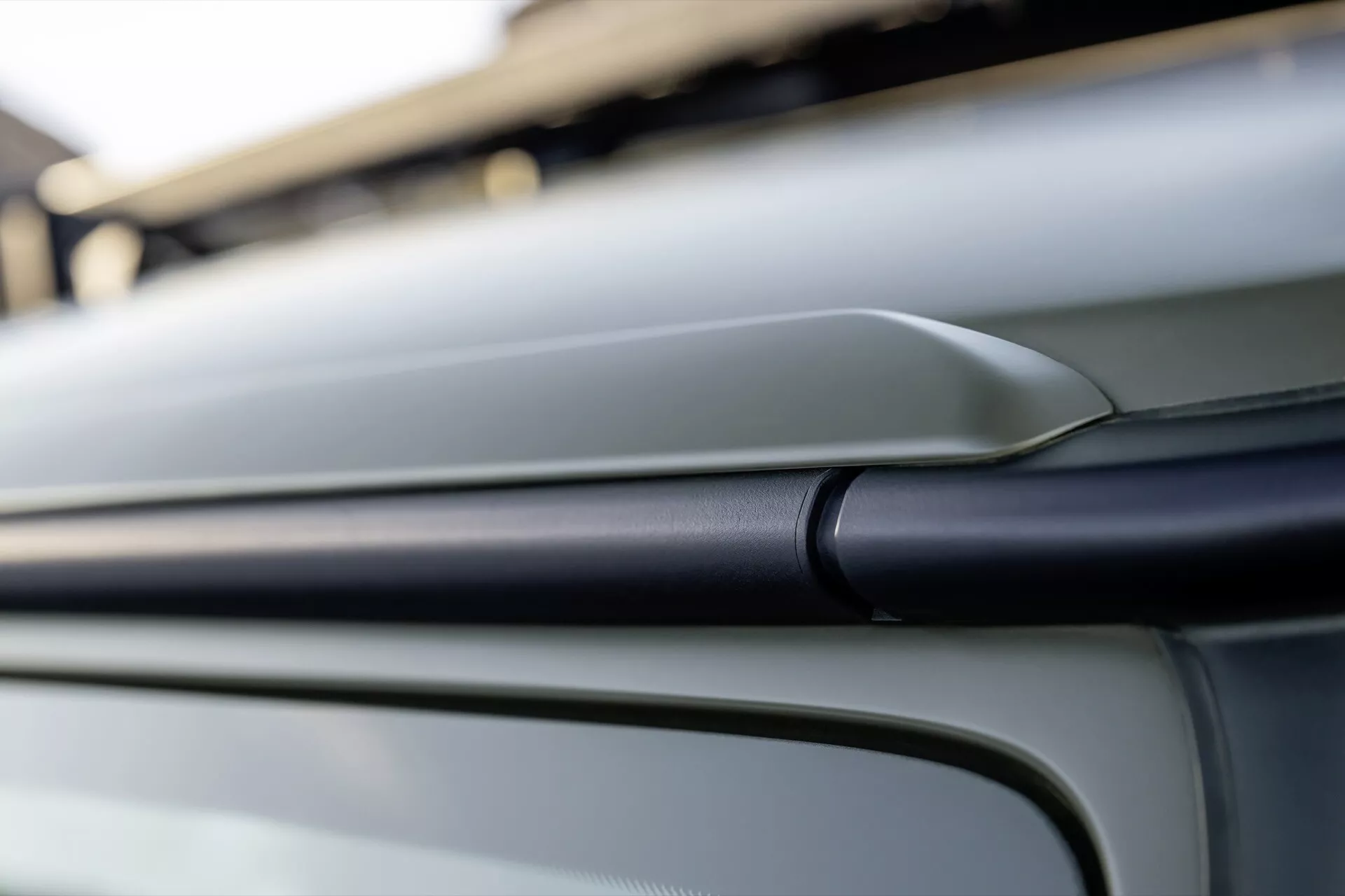 Detail exteriérového dizajnu Mercedes-Benz G-Class 2024 so zvýraznenou kontúrovou čiarou a hladkým kovovým plášťom z šikmého uhla