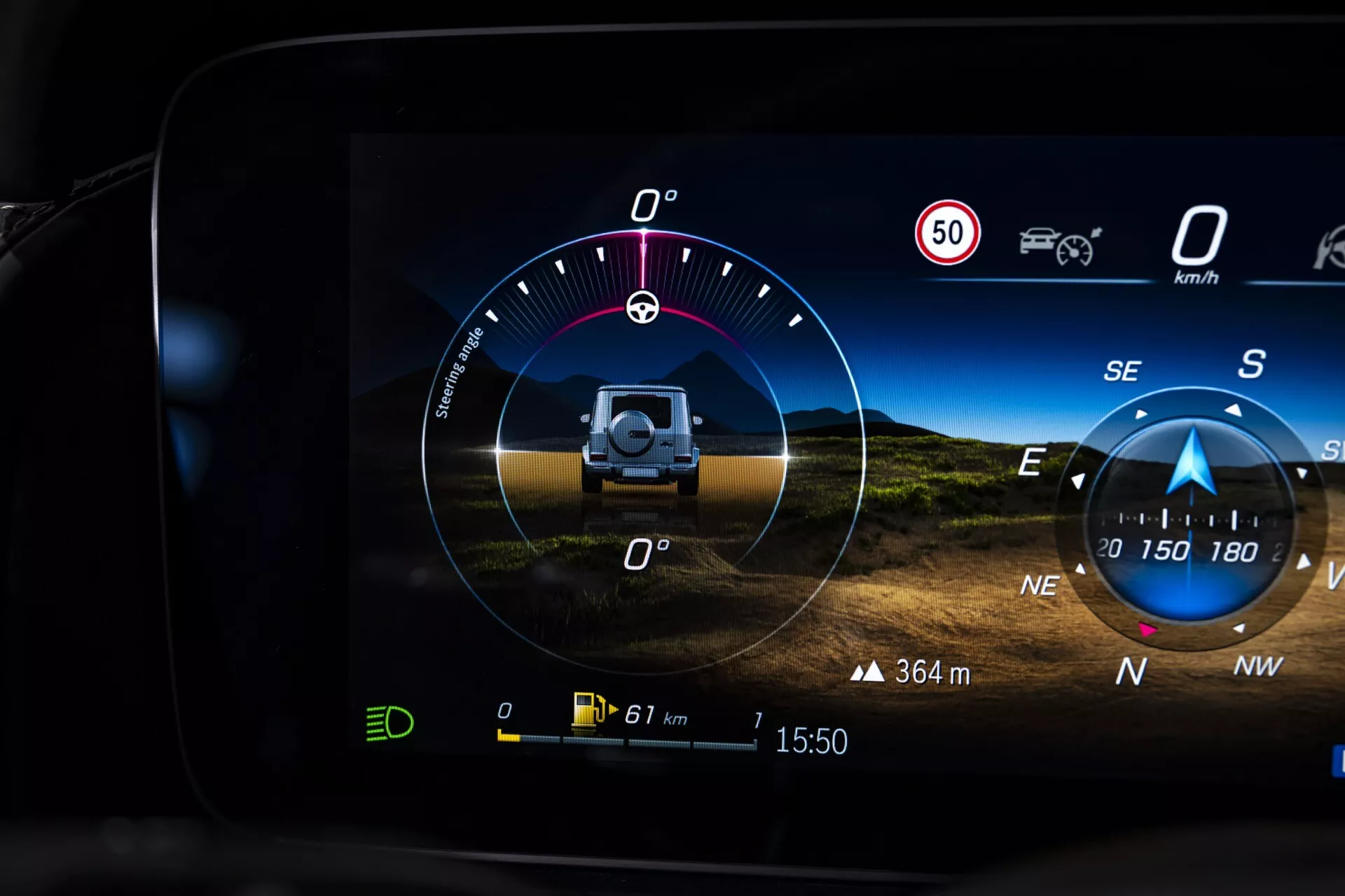 Digitálny prístrojový panel Mercedes-Benz triedy G (G-Klasse) 2024 zobrazujúci inklinometer pre jazdu v teréne, obmedzenie rýchlosti, smer vetra, údaje o sklon a náklon, kompas, dojazd vozidla, vonkajšiu teplotu a čas, čo naznačuje pokročilé navigačné a asistenčné systémy vodiča