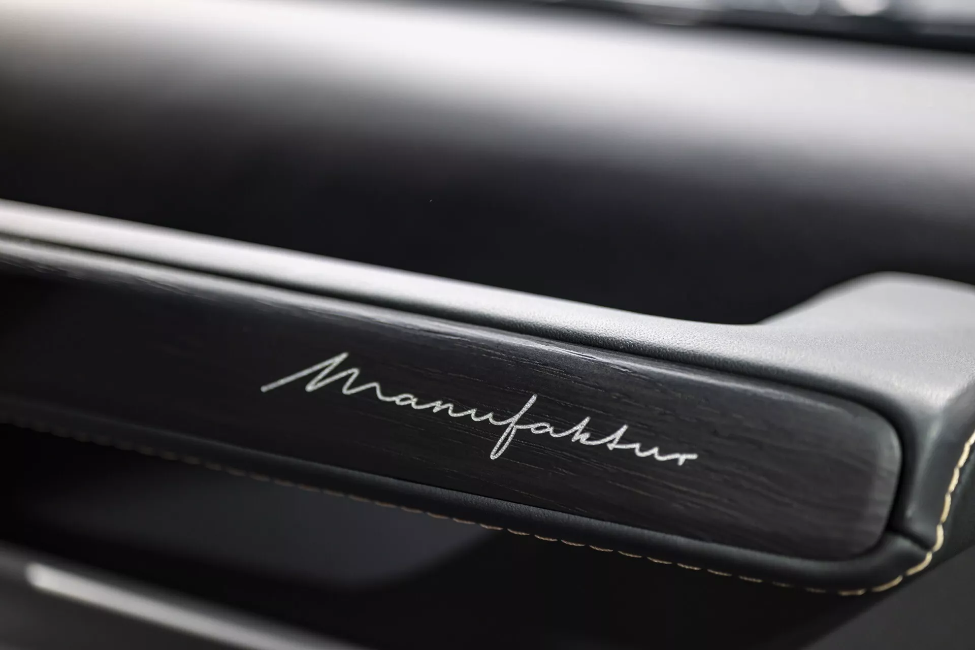 Detailný pohľad na interiér Mercedes-Benz G-Klasse 2024 so zdôraznenými detailnými švami a nápisom 'Manufaktur' na koži, čo zdôrazňuje luxusné prispôsobenie