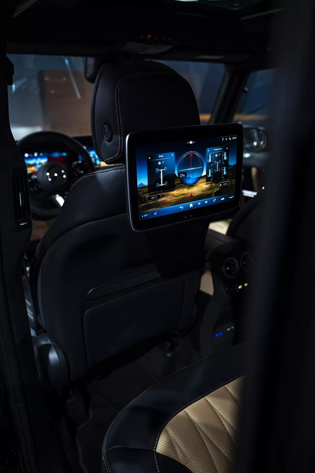 Interiér Mercedes-Benz triedy G 2024 zameraný na zadný cestujúci oddiel s vysokým rozlíšením zábavného systému na obrazovke, luxusným koženým čalúnením a ambientným osvetlením
