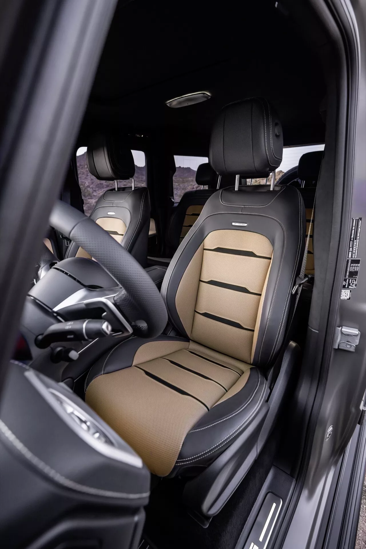 Interiér Mercedes-Benz G-Klasse 2024 so zameraním na sedadlo vodiča s luxusným dvojfarebným koženým čalúnením, pokročilými ovládacími prvkami sedadla a prvkami prémiového dizajnu