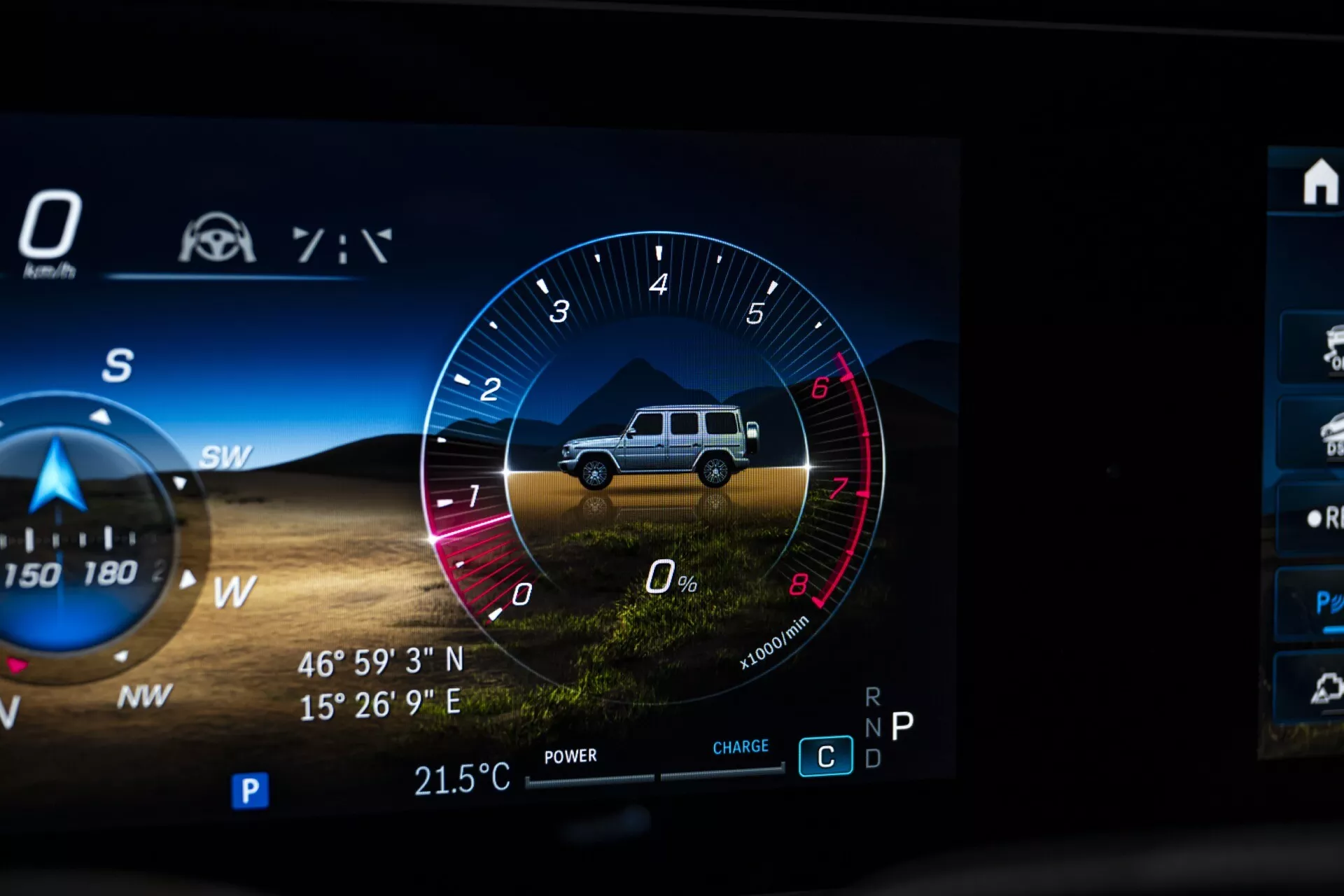 Detailný záber digitálneho palubného displeja Mercedes-Benz G-Klasse 2024 so zoskupením prístrojov pre off-road, grafikou SUV, otáčkomerom, indikátormi výkonu a nabíjania, kompasom s GPS a senzorom vonkajšej teploty