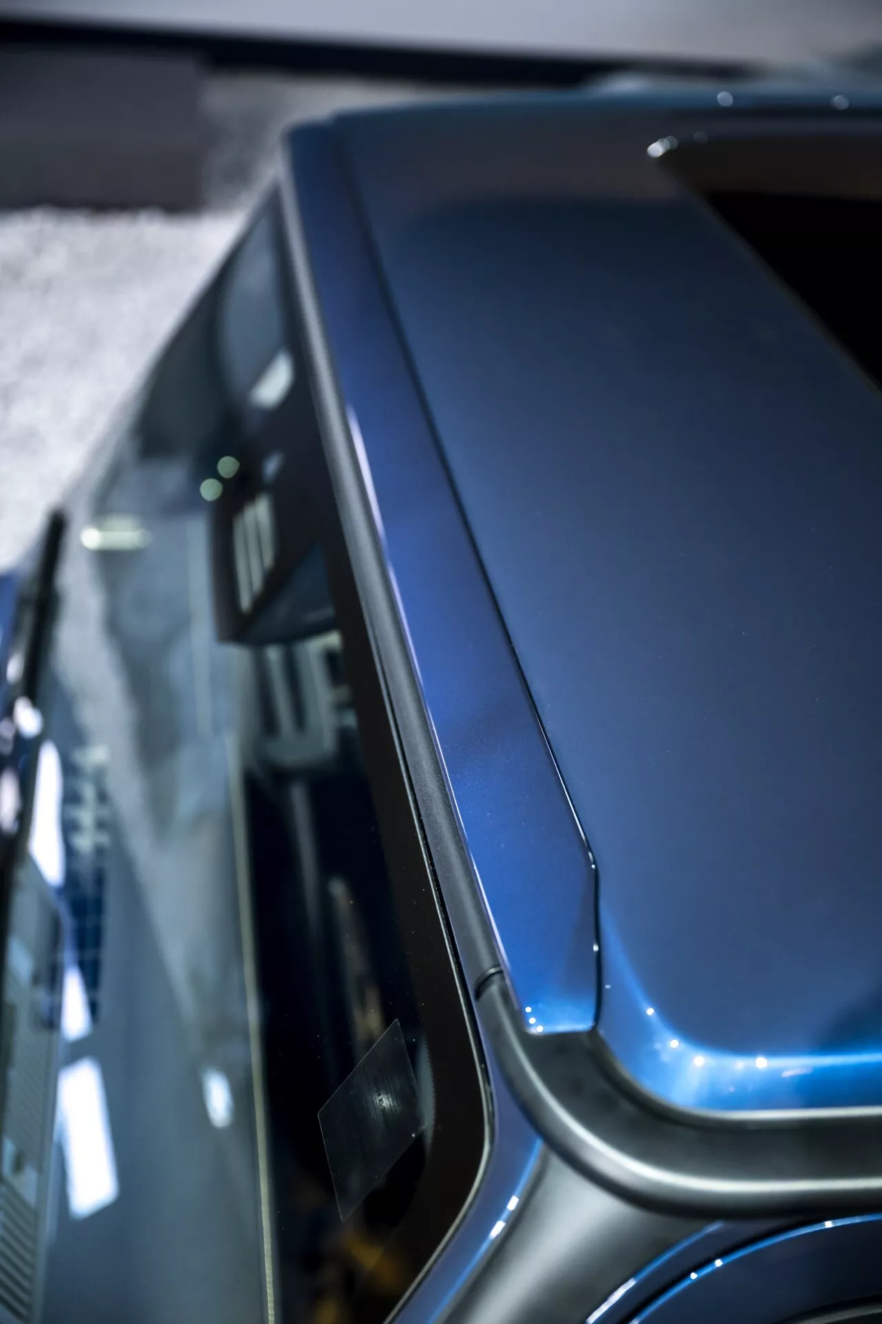 Detailný pohľad na kapotu a vrchnú časť blatníka Mercedes-Benz G-Klasse 2024 (465), ktorý zdôrazňuje jeho zakrivenie, dizajnové prvky a prémiový metalický lak zvýšeného uhla.