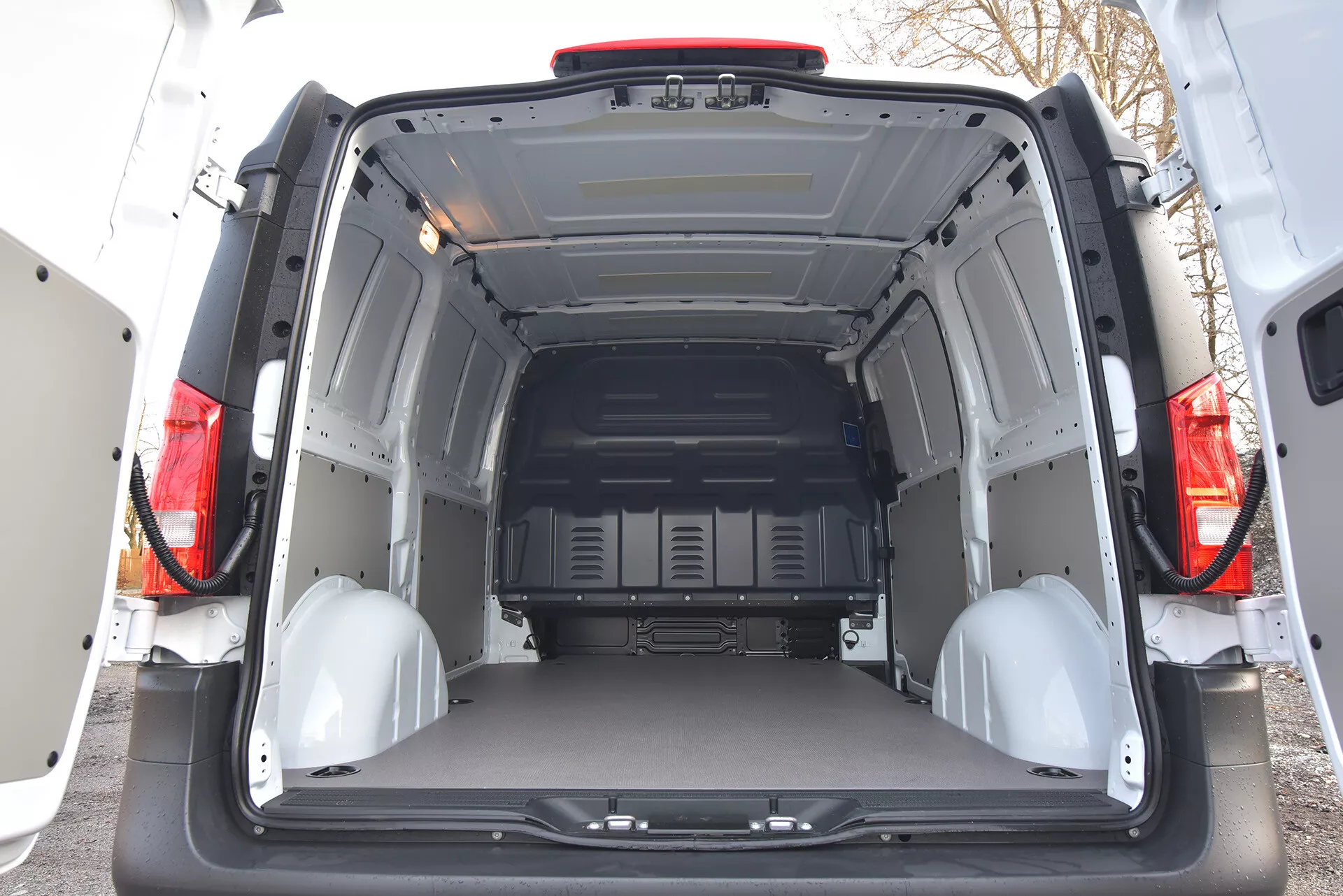 Zadný interiérový pohľad na Mercedes-Benz Vito Tourer z roku 2014 ukazujúci priestranný a prázdny nákladný priestor s otvorenými dverami, ochrannými panelmi a bodmi na upevnenie nákladu