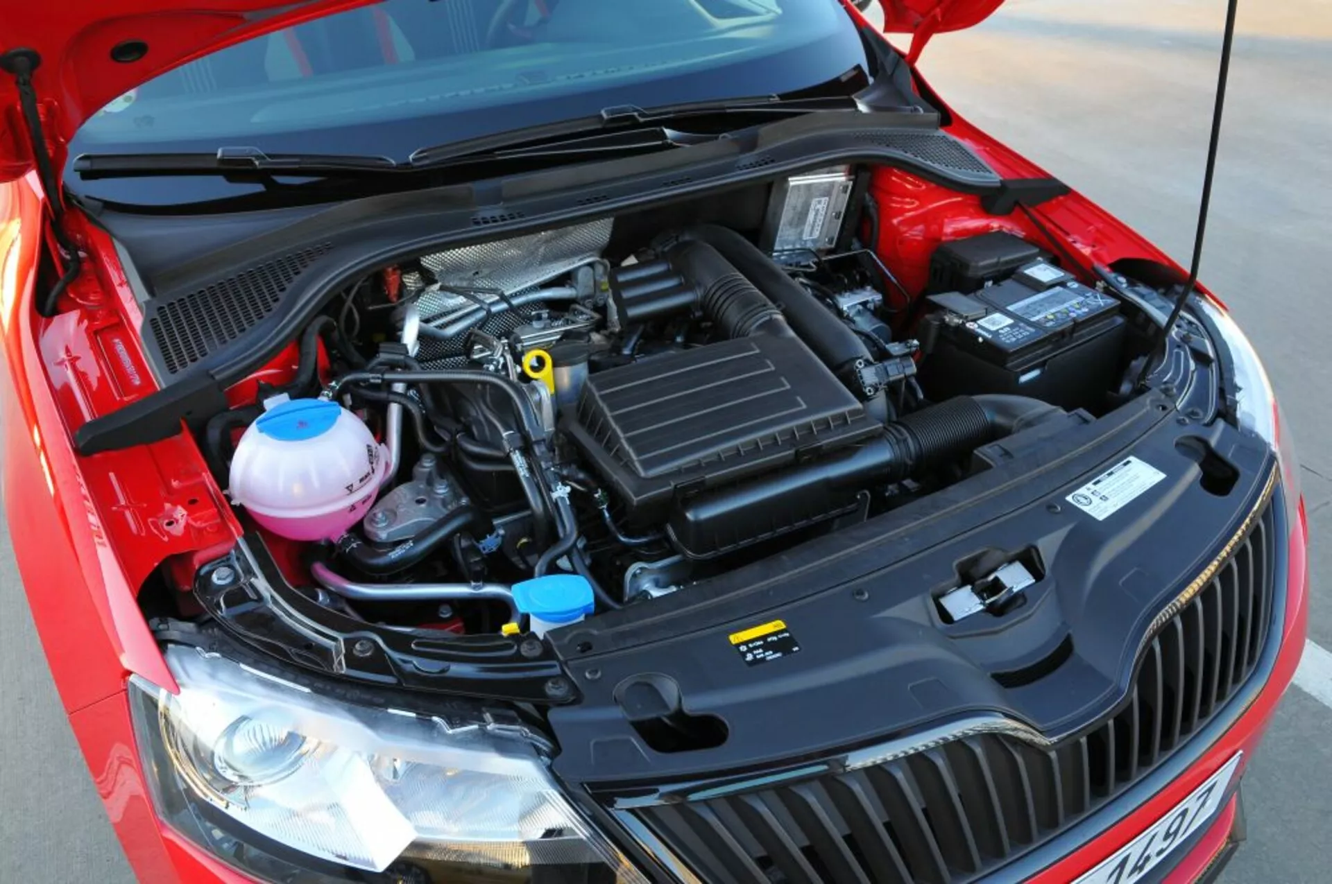 Detailný pohľad na otvorený motorový priestor Opelu Astra 2005 (Astra TwinTop), zdôrazňujúci mechanické súčasti ako sú vzduchový filter, kryt motora, nádrže na chladiacu a brzdovú kvapalinu a batériu z ľahko zvýšenej frontálnej perspektívy