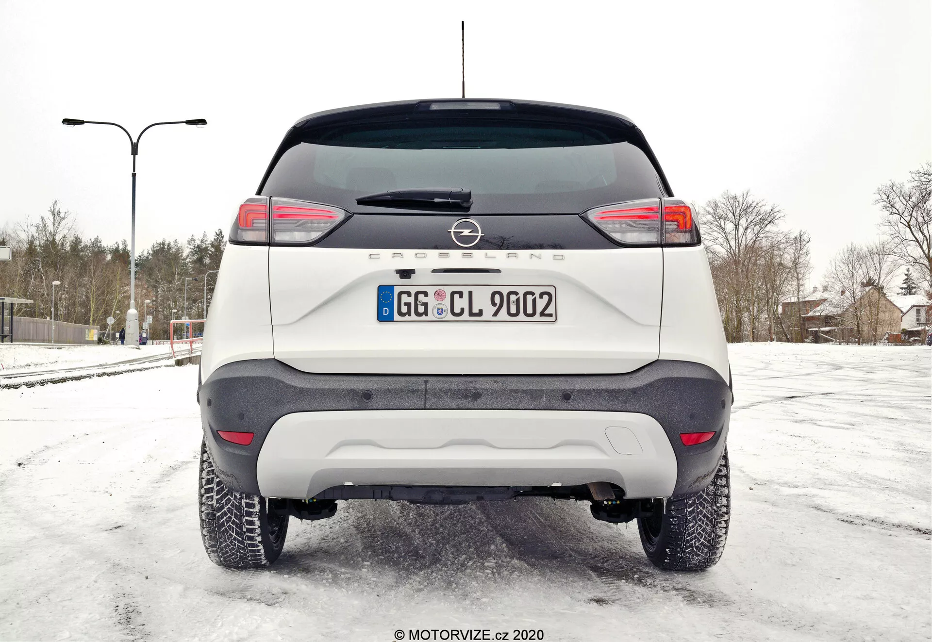 Bočný pohľad na Opel Crossland 1.2 z roku 2021 v impozantnom mestskom prostredí, zdôrazňujúci jeho elegantný dizajn a moderné funkcie
