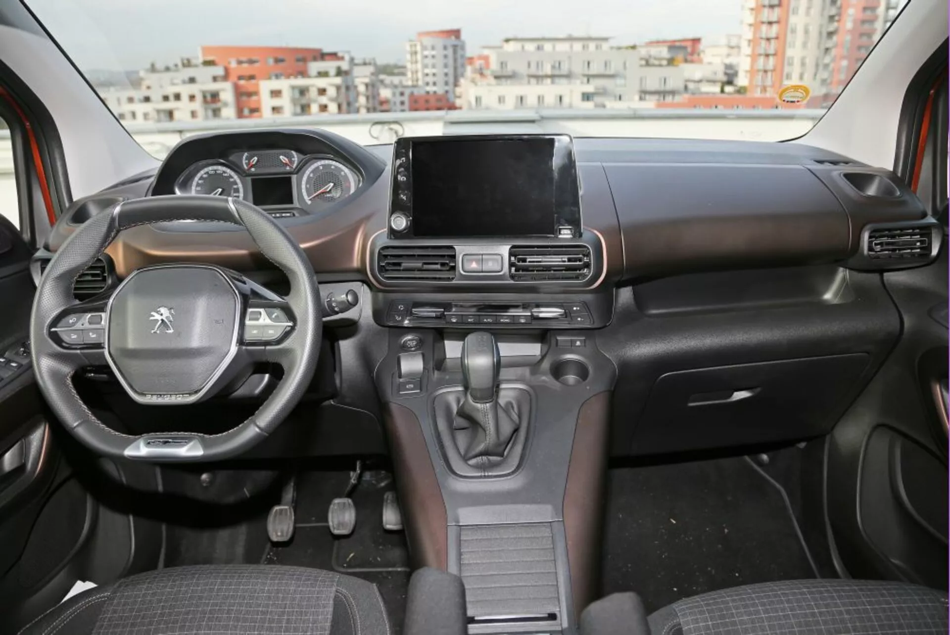 Interiérový pohľad na Peugeot 3008 z roku 2016 ukazujúci palubnú dosku, volant s ovládacími prvkami a centrálny dotykový displej informačno-zábavného systému z perspektívy zadného sedadla