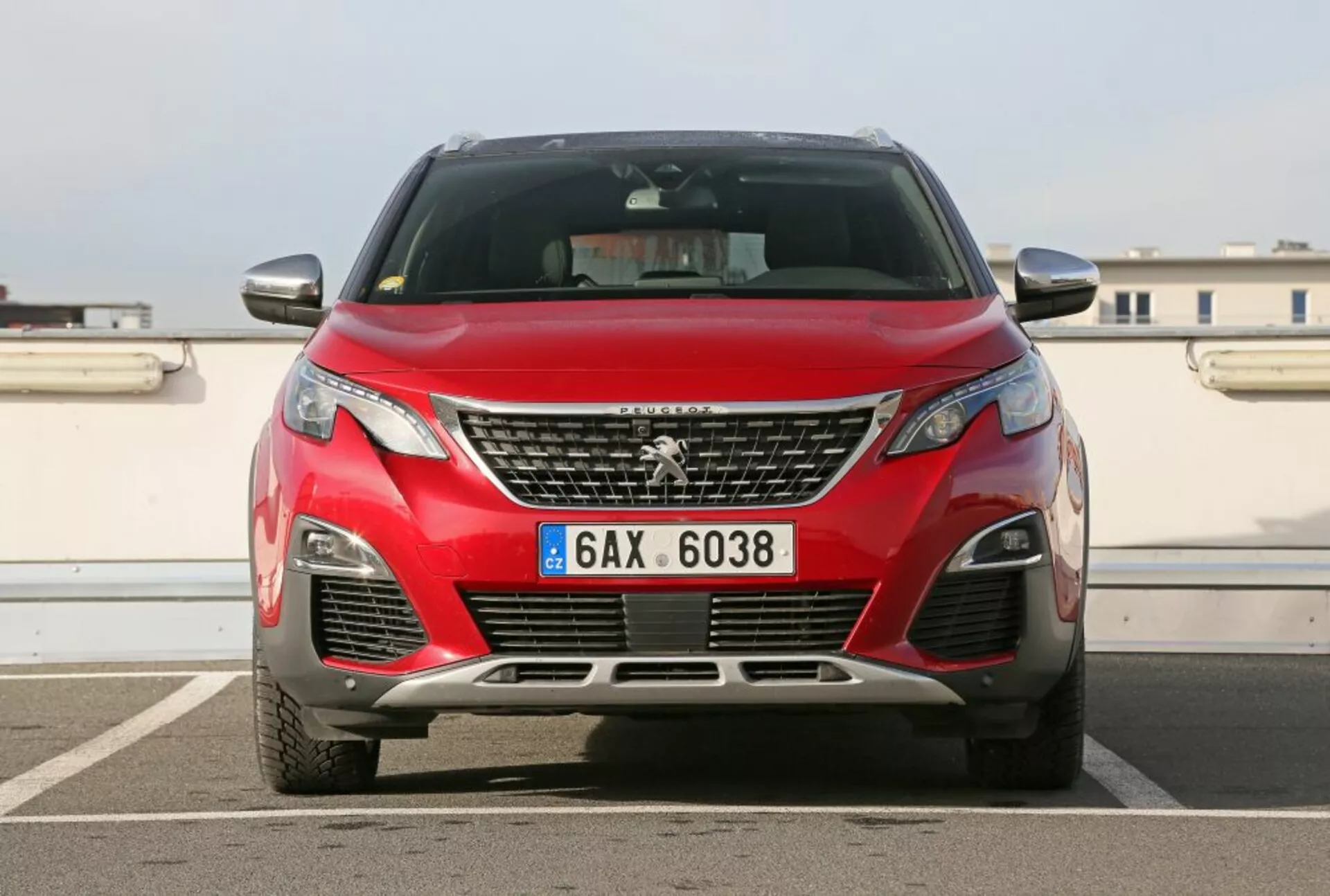 Predný pohľad na červený Peugeot 3008 z roku 2016 s chrómovou mriežkou a emblémom, modernými LED svetlometmi a prvkami aerodynamického dizajnu, fotografovaný vonku