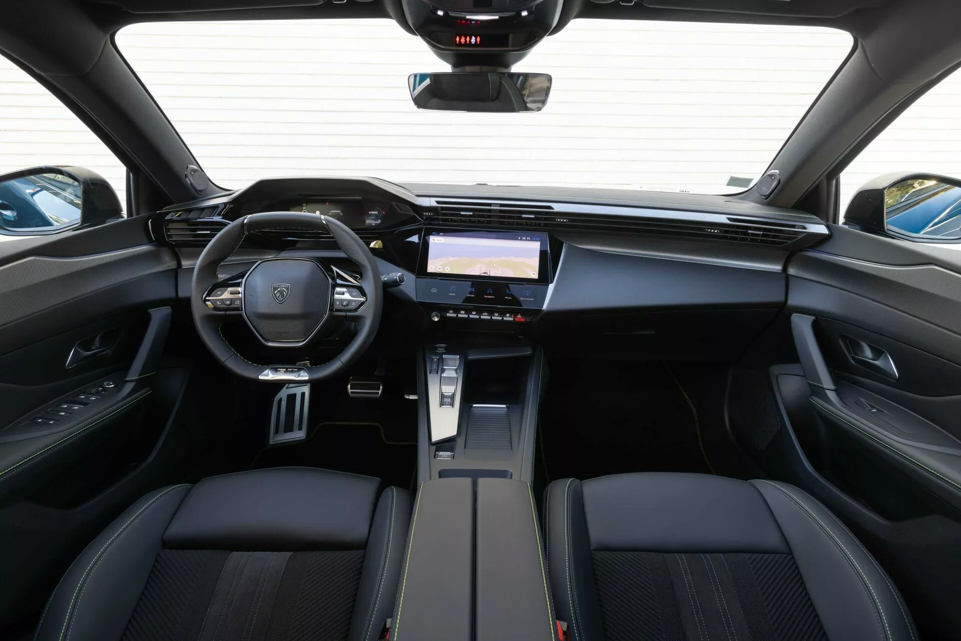 Interiér Peugeot 408 z roku 2023 z pohľadu zo zadných sedadiel zvýrazňuje palubnú dosku, multifunkčný volant so znakom značky a pokročilý informačno-zábavný systém