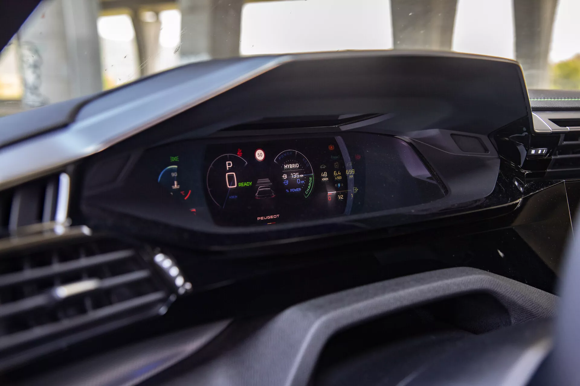 Interiér Peugeot 408 2023 so zameraním na modernú digitálnu palubnú dosku z pohľadu sedadla vodiča, zdôraznenie digitálneho prístrojového panelu s vozidlom v režime parkovania a s vysokou úrovňou nabitia batérie