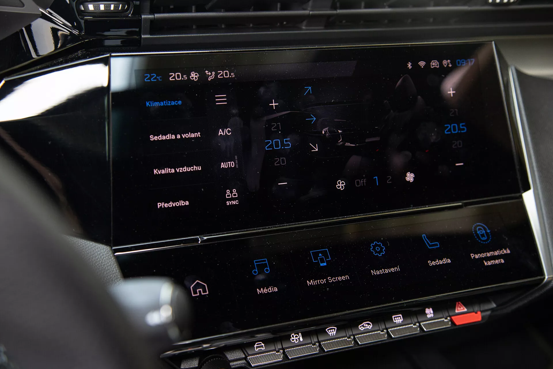 Centrálna konzola Peugeot 408 2023 ukazujúca dotykový infotainment systém a rozhranie na ovládanie klímy s nastavením teploty a pokročilými funkciami
