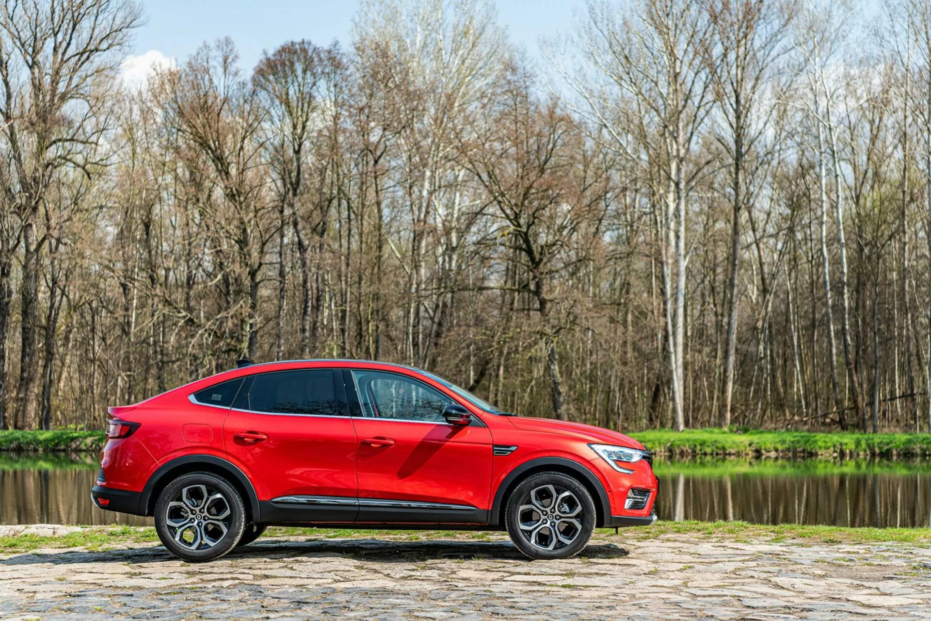 Predný pohľad na Renault Arkana 2021 v elegantnom, modernom dizajne s elegantnými LED svetlometmi a odvážnou, dynamickou mriežkou, ktorá zvýrazňuje jeho športový, no elegantný vzhľad.