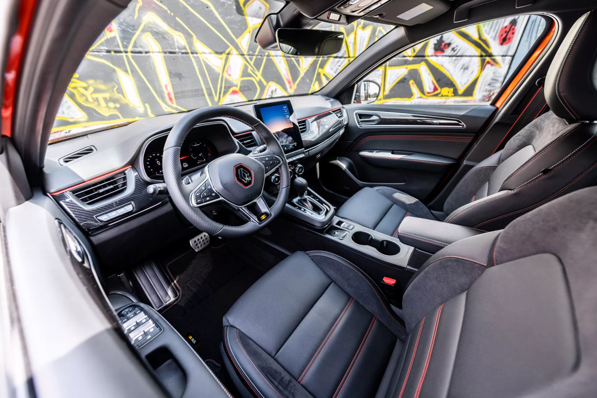 Interiér Renault Arkana 2021 z pohľadu spolujazdca s volantom pre médiá a tempomat, digitálnym palubným počítačom, systémom infotainment, automatickou prevodovkou, športovými sedadlami s luxusnými detailmi a pokročilými technologickými prvkami