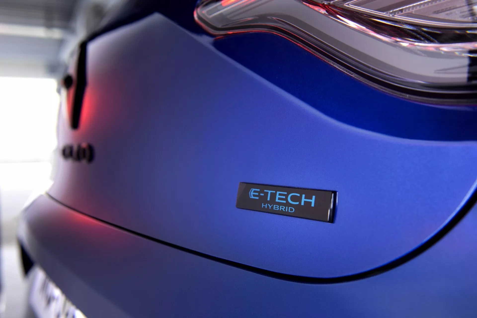 Detailný pohľad na Renault Clio V-Facelift 2023, zadný panel s odznakom E-TECH HYBRID a metalickou modrou farbou