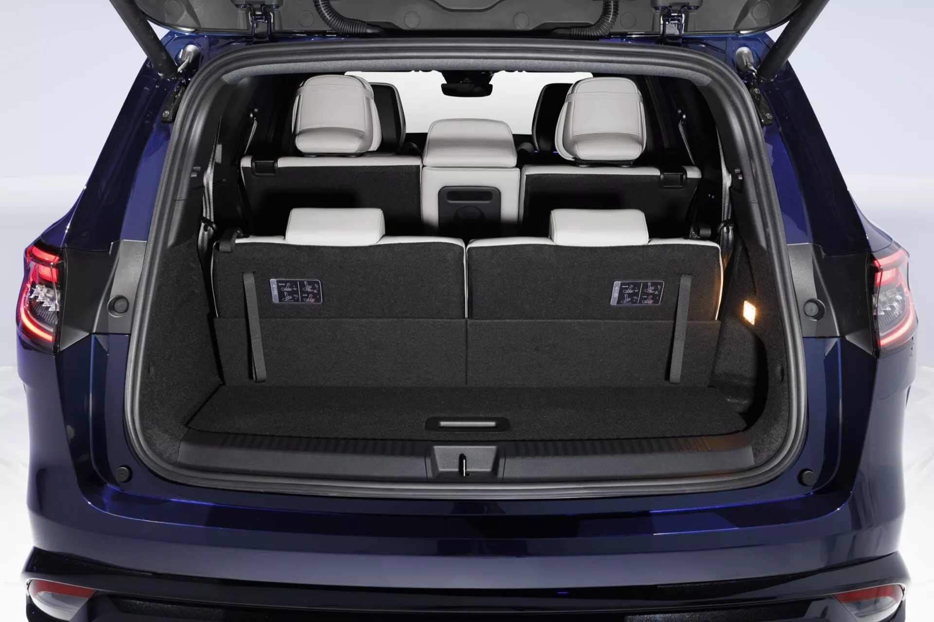 Renault Espace VI 2023 zobrazujúce zadnú časť s otvoreným kufrom, priamy zadný pohľad do čistého, dobre osvetleného priestoru kufra zdôrazňujúce kapacitu nákladu a zložené sedadlá tretieho radu s rozdelením 50/50 v možnom béžovom alebo sivom interiéri