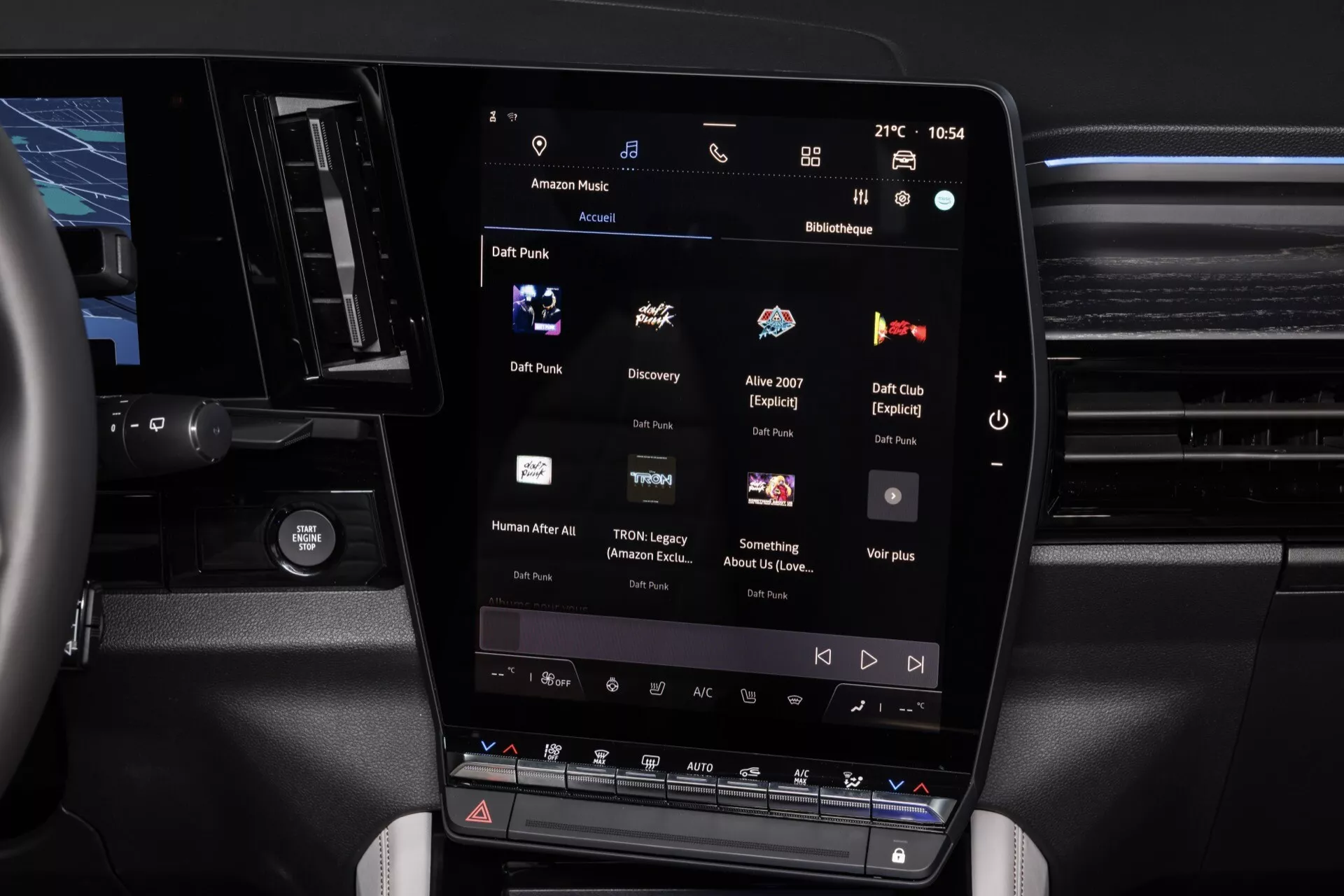 Detailný pohľad na interiér Renault Espace 2023 sústredený na vertikálne orientovaný centrálny dotykový displej infotainmentu zobrazujúci aplikáciu prehrávača médií, s tlačidlami klimatizácie nižšie, naznačujúci luxusné prvky kabíny a moderný dizajn.