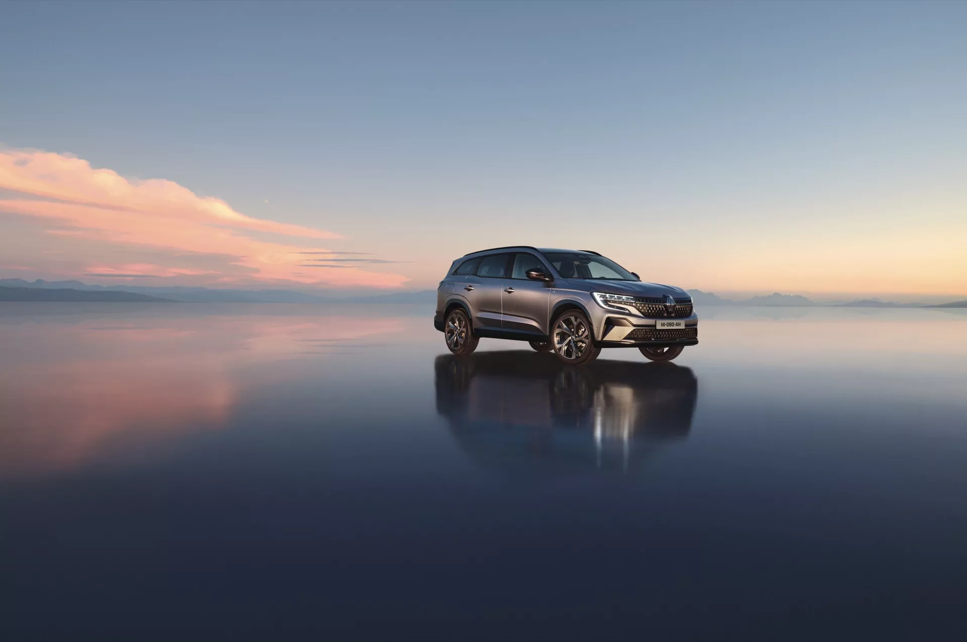 Renault Espace VI 2023 na odrazivej ploche ukazujúci prednú mriežku, LED svetlomety a zliatinové kolesá z trojštvrtečného predného pohľadu, zdôrazňujúci aerodynamický dizajn a pokročilé technologické vlastnosti
