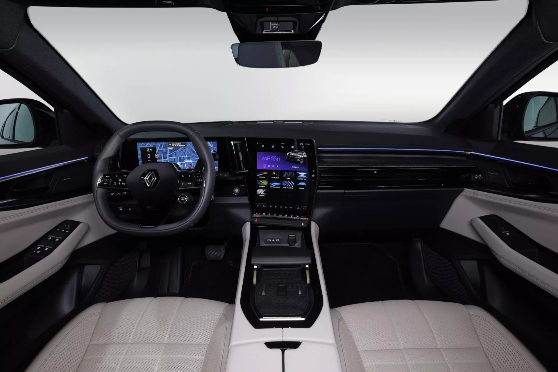 Interiér Renault Espace VI 2023 z pohľadu zo stredného zadného sedadla ukazuje Volant so Ovládacími Tlačidlami, Digitálny Prístrojový Panel, Dotykový Infotainment Systém, Ambientné Osvetlenie, Sedadlá z Dvojfarebnej Kože, Modernú Výberovú Páku, Materiály Vysokej Kvality a Štýlové Dizajnové Prvky
