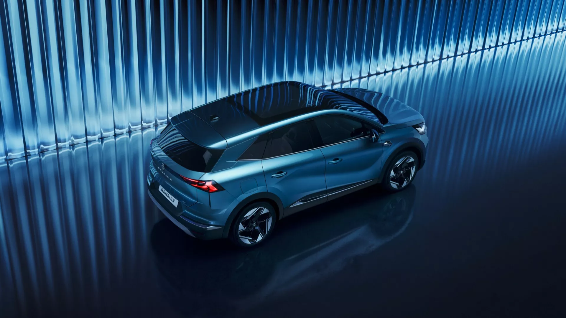 Pohľad zhora na SUV Renault Symbioz 2024, zobrazujúci elegantný, aerodynamický dizajn s panoramatickou strechou a viacramennými zliatinovými kolesami, odrážajúci vysoko kvalitné materiály a moderné technológie v štúdiovom prostredí.