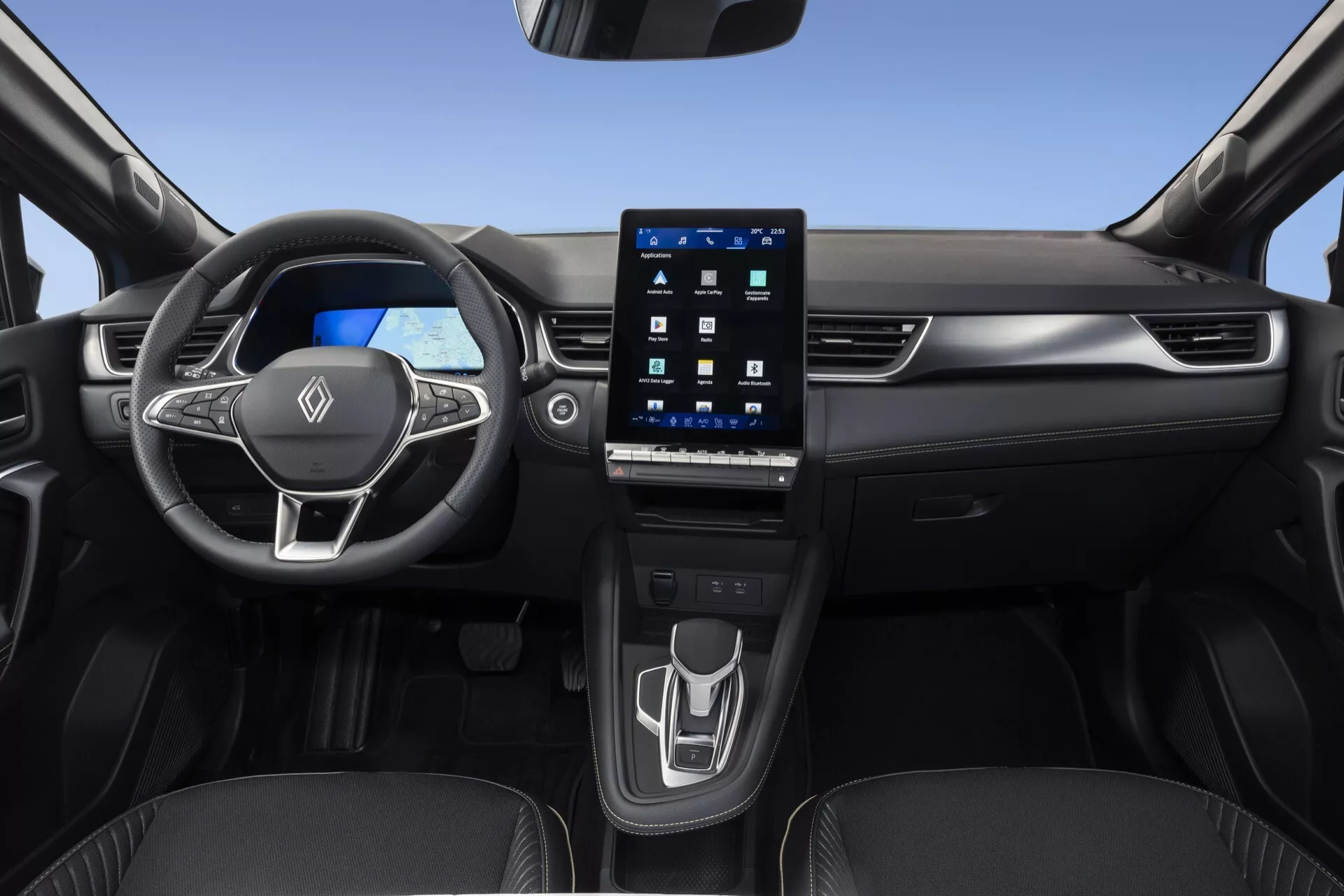Pohľad do interiéru vozidla Renault Symbioz 2024 z predného sedadla spolujazdca, predstavuje multifunkčný trojramenný volant s ovládacími prvkami, jasný digitálny prístrojový panel a veľký portraitne orientovaný dotykový infotainment displej integrovaný do stredovej konzoly. Moderná stredová konzola zahŕňa minimalistický dotykový ovládací panel pre nastavenie klimatizácie a moderný elektronický volič prevodov, spolu s viditeľnými držiakmi na nápoje. Vozidlo má elegantný dizajn s použitím prémiových materiálov a zladených panelov na dverách, zamerané na pokročilé automobilové technológie, digitálne prístroje a pohodlie používateľa.