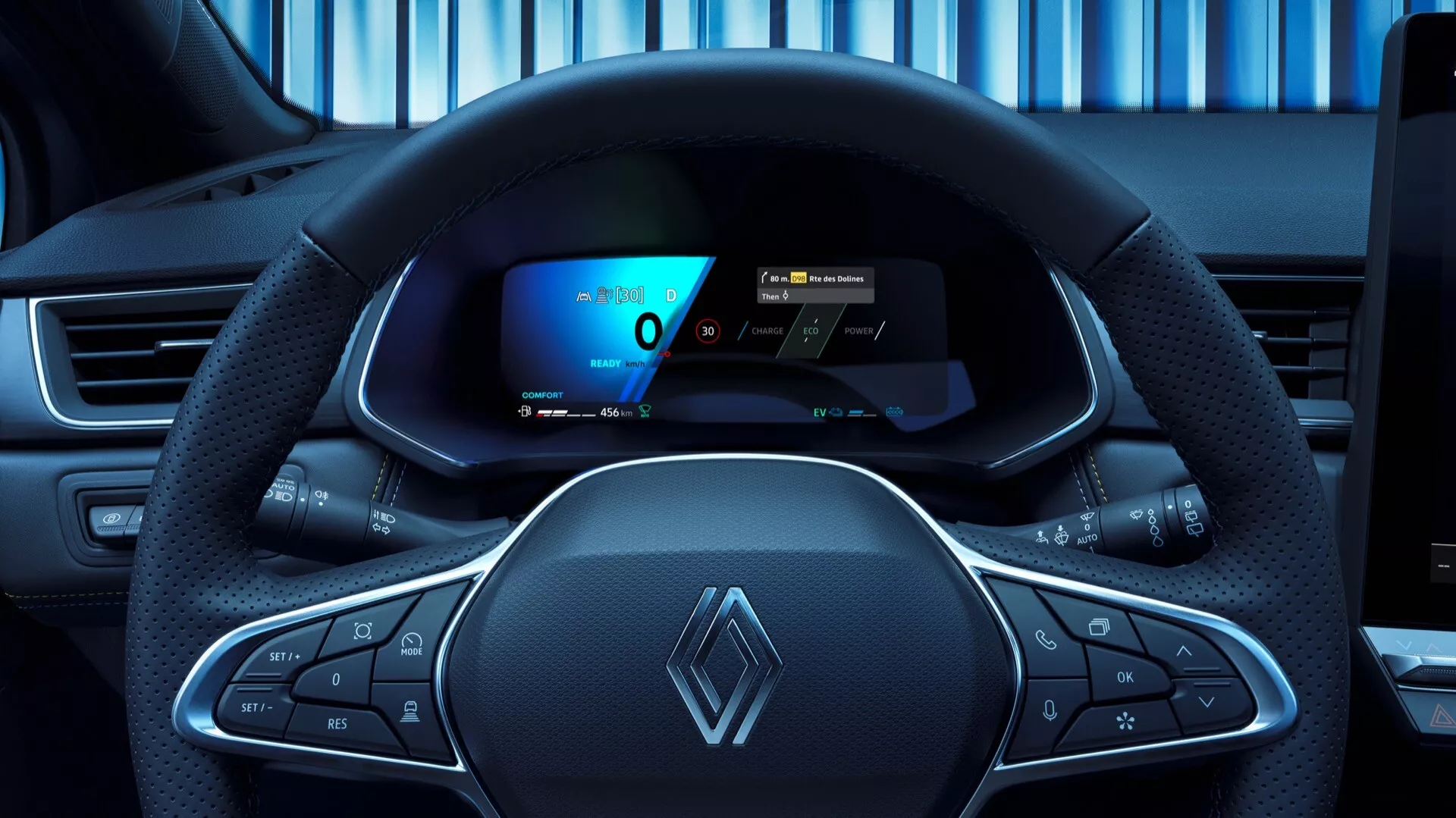 Pohľad z pozície vodiča na Renault Symbioz 2024 prvej generácie, predstavujúci moderný, mierne športový dizajn volantu s multifunkčnými tlačidlami a výrazným logom Renault. Digitálny prístrojový panel za volantom zobrazuje rýchlomer, ukazovateľ výkonu a navigačnú mapu, čo zvýrazňuje pokročilú technológiu vozidla. Palubná doska naznačuje možnú centrálnu dotykovú obrazovku infotainment systému.