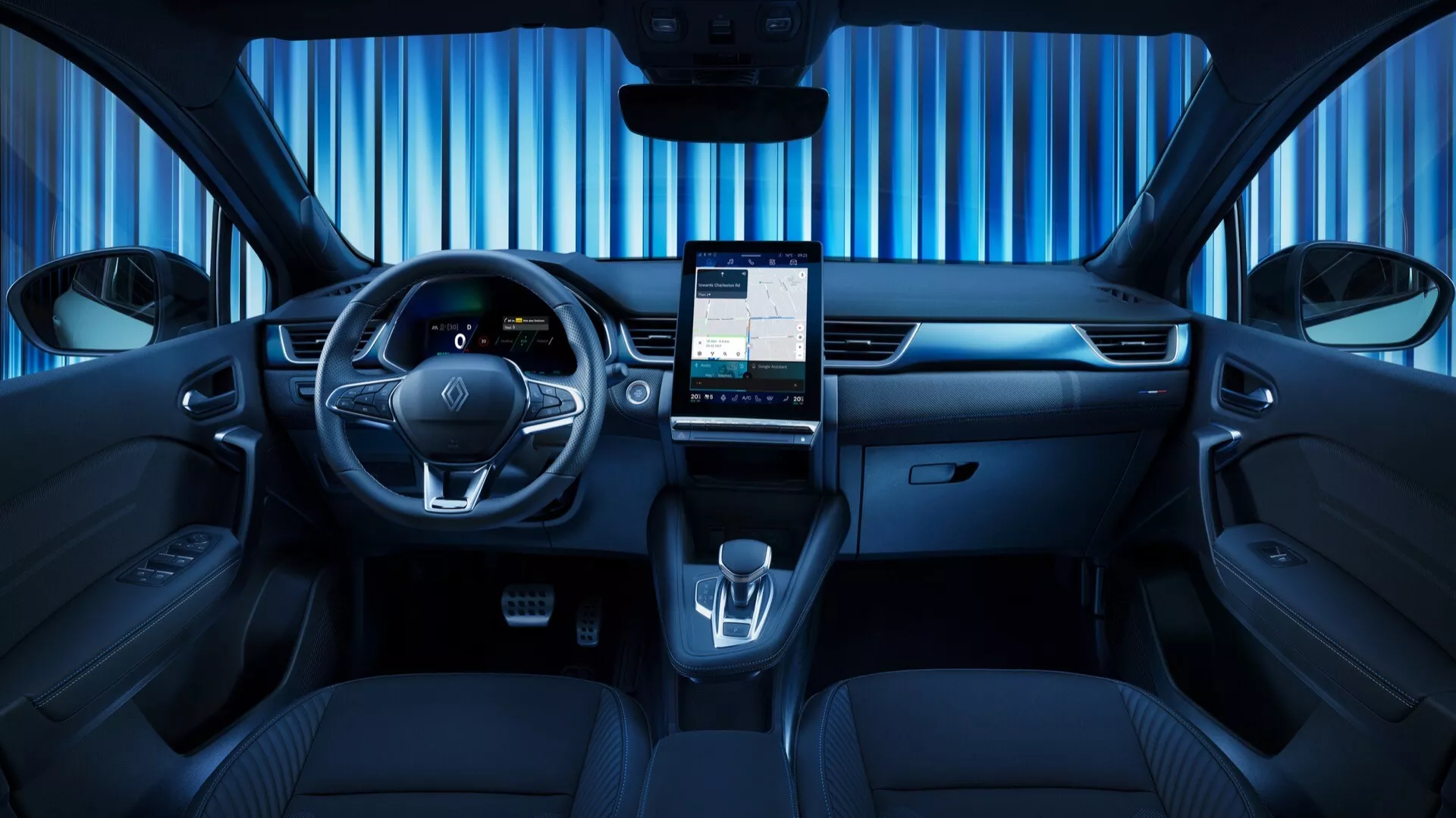 Interiér Renault Symbioz 2024, prvej generácie, fotený zo stredného zadného uhla, ukazujúci elegantnú prednú prístrojovú dosku, multifunkčný volant s ovládacími tlačidlami, digitálny prístrojový panel, veľkú vertikálnu dotykovú obrazovku pre infotainment, minimálne fyzické ovládacie prvky, elektronický volič prevodovky, držiaky na nápoje, tmavo čalúnené sedadlá s detailným prešívaním, odrážajúci vysoce techologický a moderný dizajn.